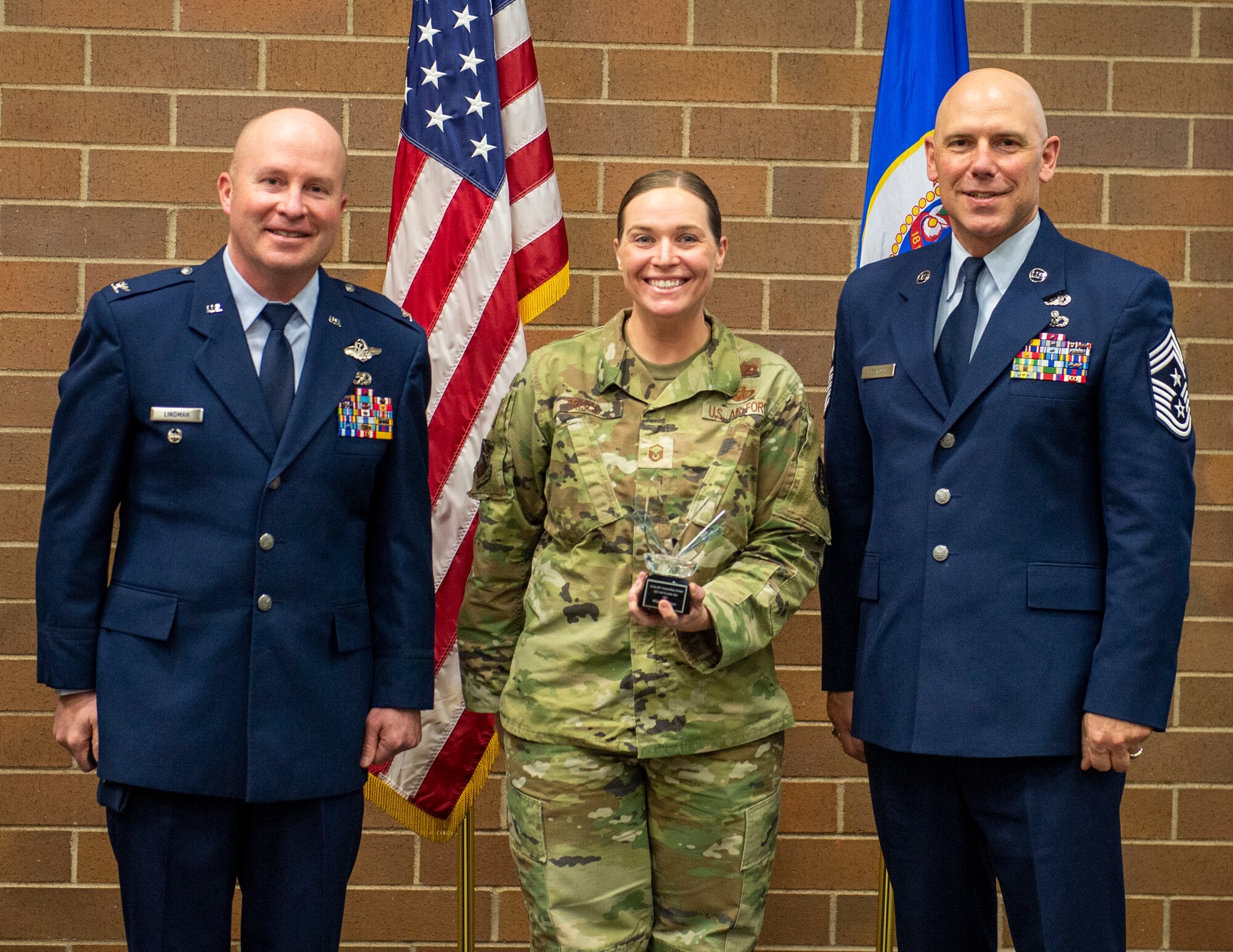 U.S. Air Force Master Sgt. Allison Trisco, 133rd Force Support Squadron, accepts the Outstanding Airman of the Year award for Master Sgt. Shane Trisco in St. Paul, Minn., Dec. 11, 2021.