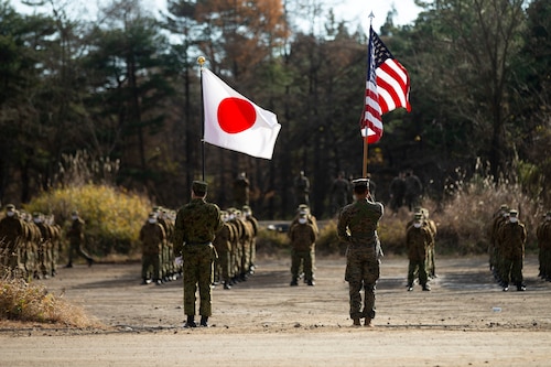 US and Japanese service members carry their respective flags during opening ceremonies of Resolute Dragon 21