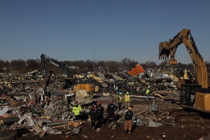 Army Guardsmen with the 301st Chemical Battalion and Air Guardsmen with the 123rd Airlift Wing search for survivors of devastating tornadoes in Mayfield, Ky., Dec. 12, 2021. More than 300 Guardsmen were activated to assist.