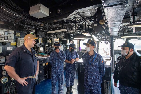 Cmdr. Bryan Gallant, the executive officer aboard the forward-deployed amphibious dock landing ship USS Rushmore (LSD 47), conducts a tour of the ship’s pilot house for allies from the Japan Maritime Self-Defense Force. Rushmore, part of Amphibious Squadron 11, is operating in the U.S. 7th Fleet area of responsibility to enhance interoperability with allies and partners and serve as a ready response force to defend peace and stability in the Indo-Pacific region.