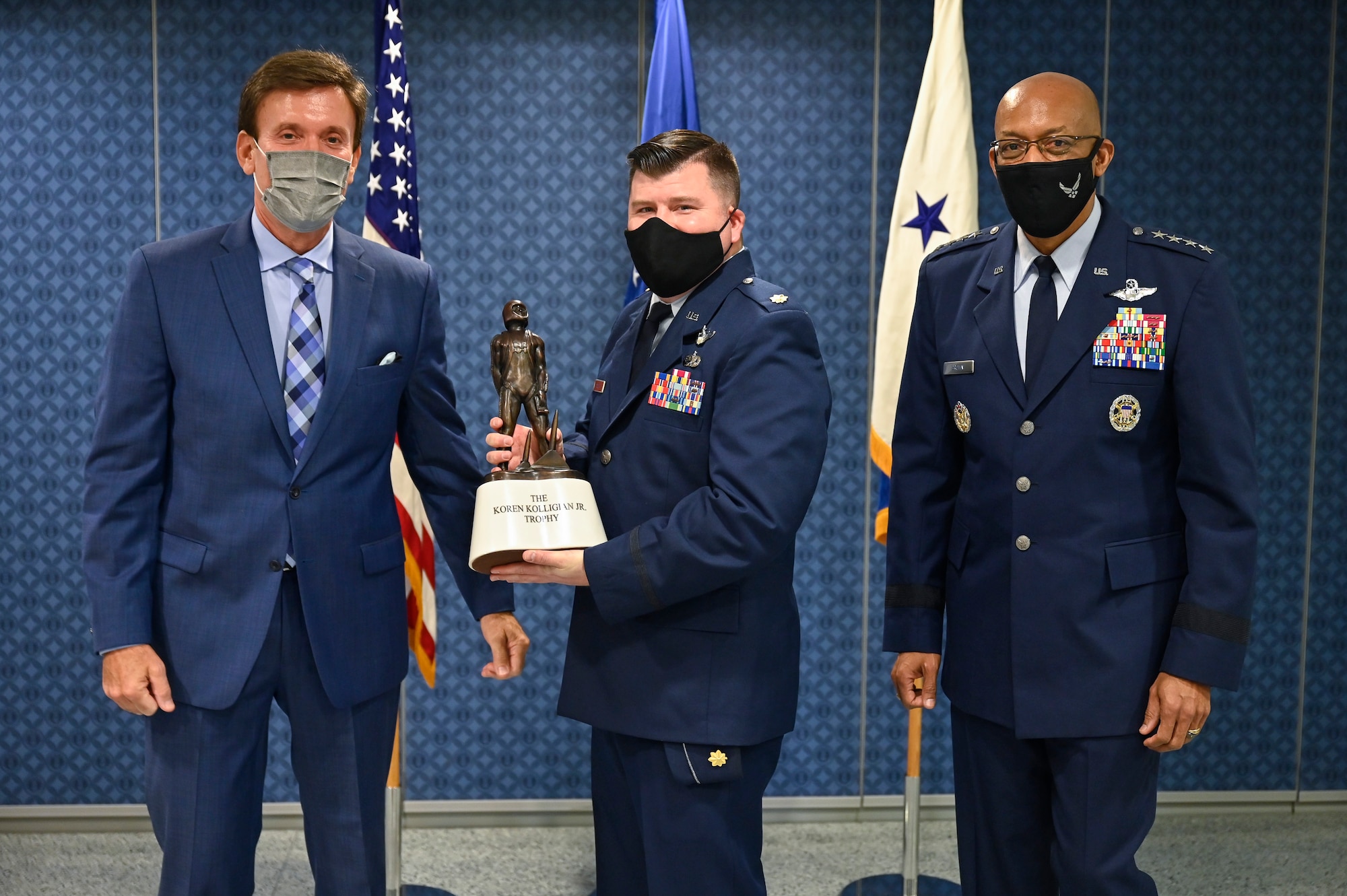 Photo of Maj. Justin Sager posing with Koren Kolligian II, left, and Air Force Chief of Staff Gen. CQ Brown, Jr. after receiving the 2019 Koren Kolligian Jr. Trophy