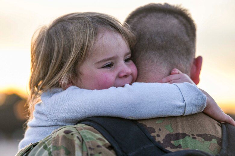 An Airman greets his daughter upon returning from deployment.