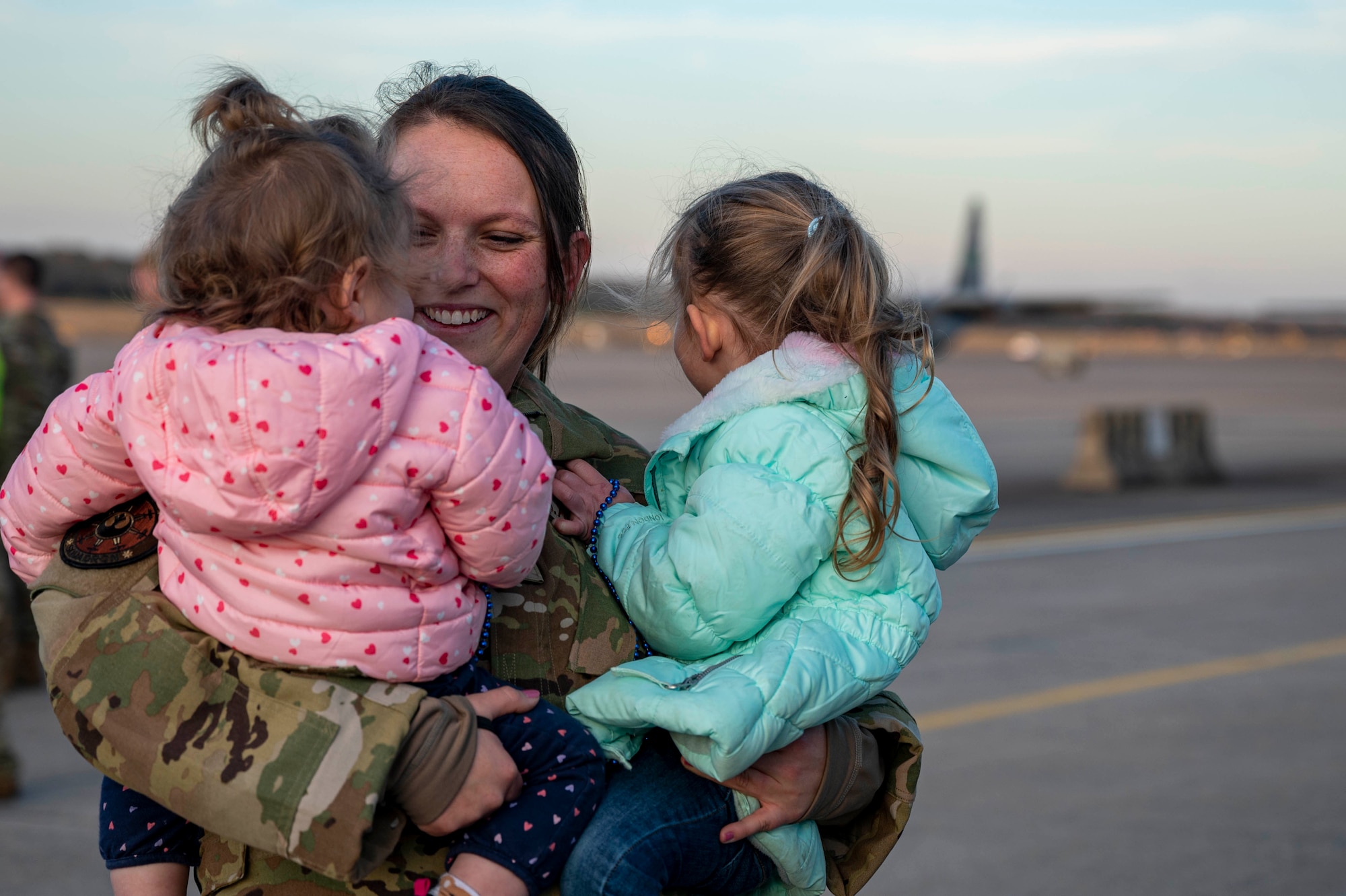 An Airmen greets her daughters upon returning from deployment.