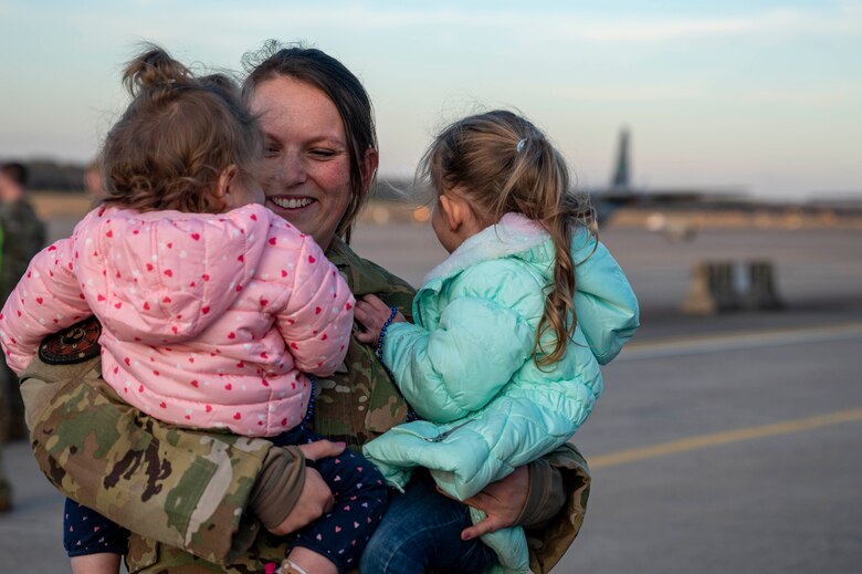 An Airmen greets her daughters upon returning from deployment.
