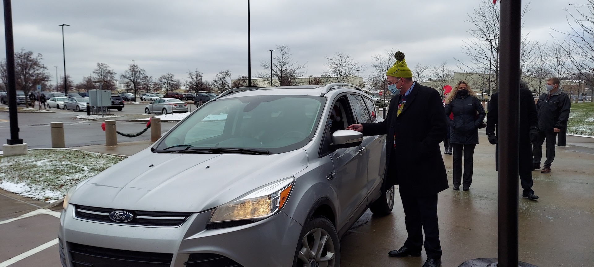 DLA Land and Maritime Director of Operations Griff Warren greets a person in a car. He is wearing a Grinch hat.