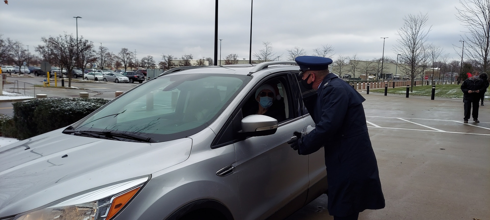 DLA Land and Maritime Chief of Staff Air Force Col. Christopher Tooman in Air Force attire chats with a person in a car.