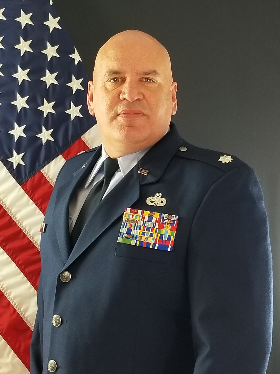 Lt. Col. Cox poses for a photo in service dress with an American flag in the background
