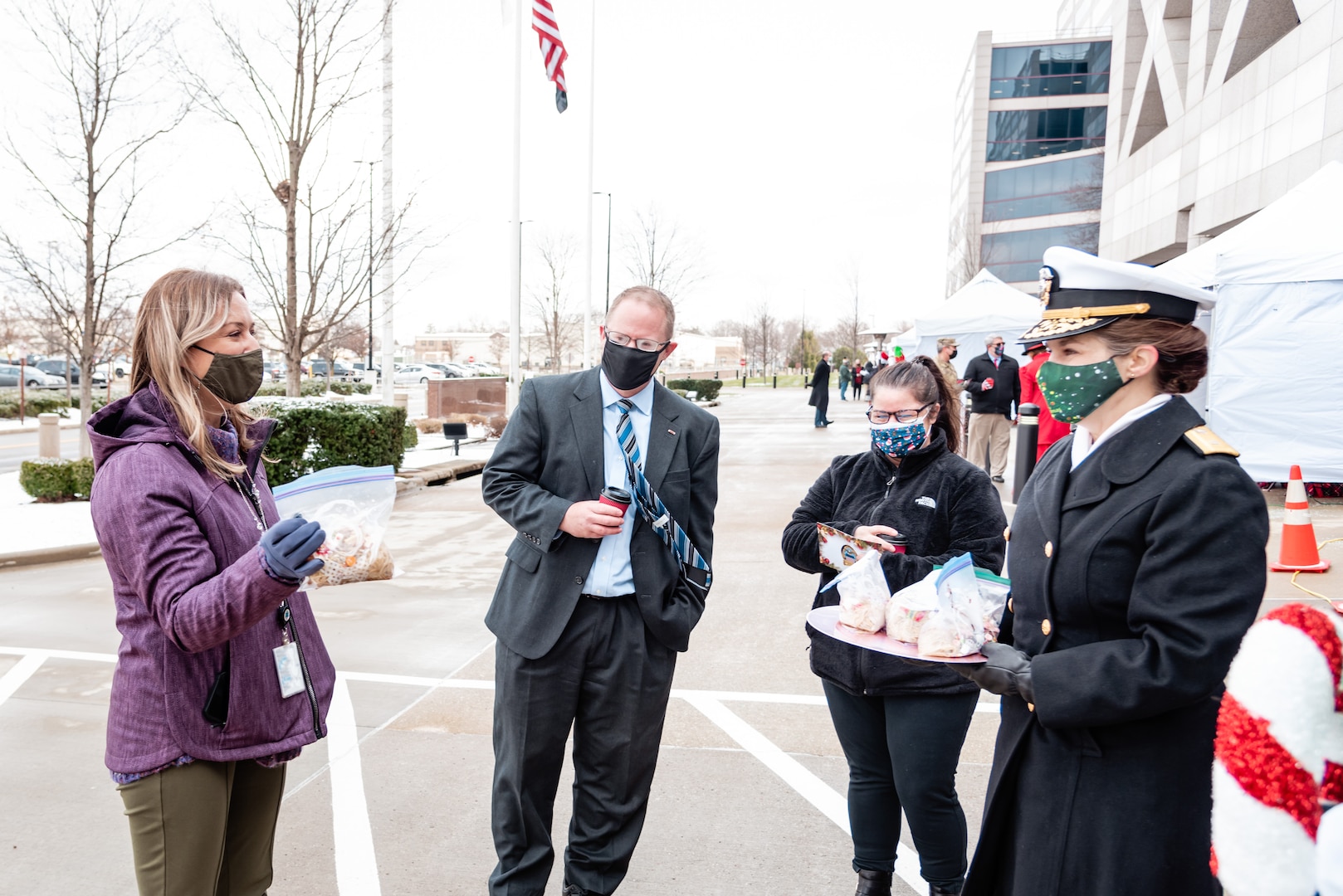 DLA Land and Maritime Commander Navy Rear Adm. Kristen Fabry  with several people in winter attire outside of Building 20.