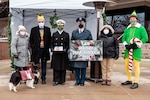 A group of people dressed in holiday attire posing for a photo.