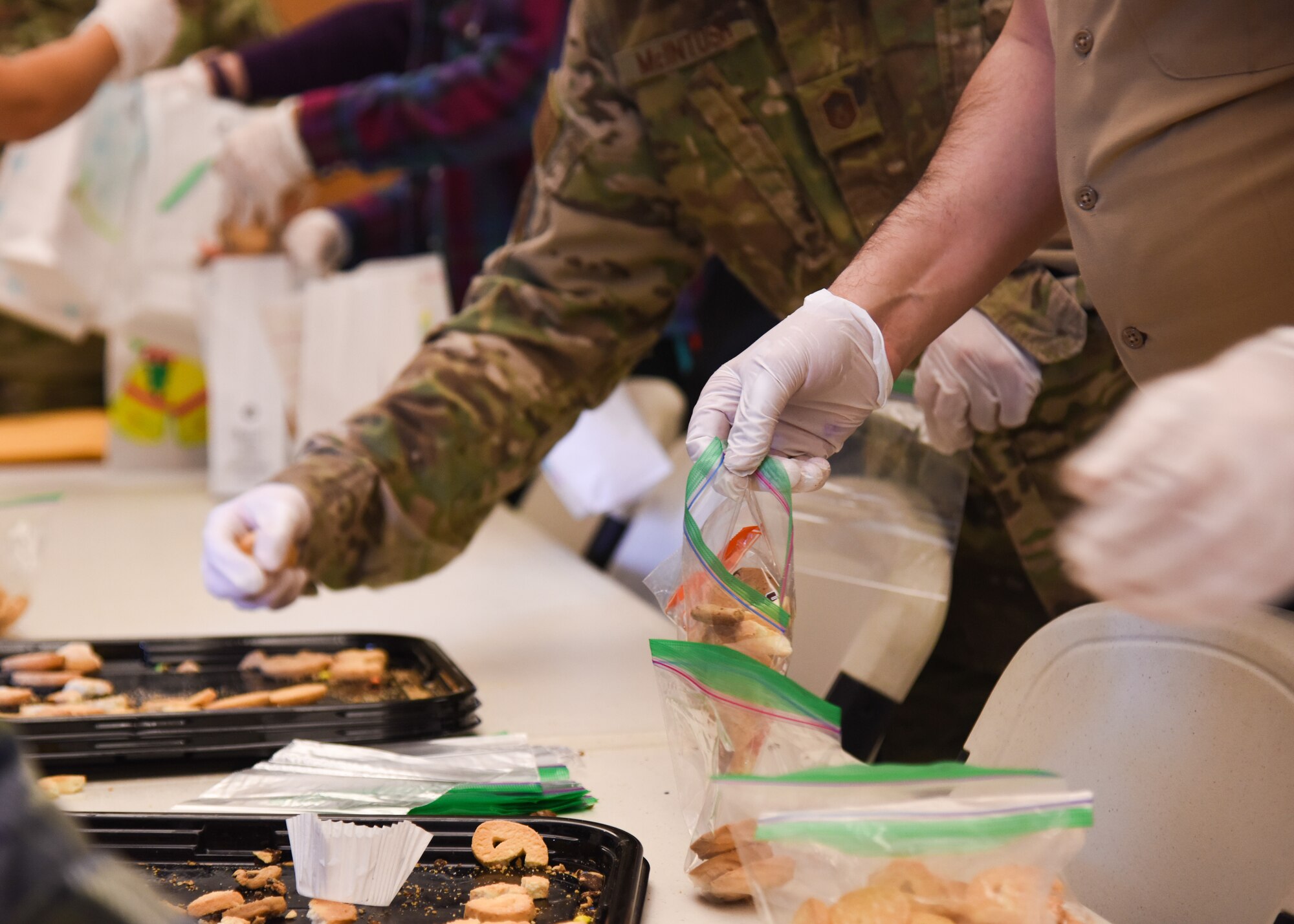 Goodfellow members prepare bags of cookies during the Cookie Caper event, Dec. 7, 2021, on Goodfellow Air Force Base, Texas. Donations were accumulated at the Chamber of Commerce and at the Consolidated Learning Center. (U.S. Air Force photo by Staff Sgt. Tyrell Hall)