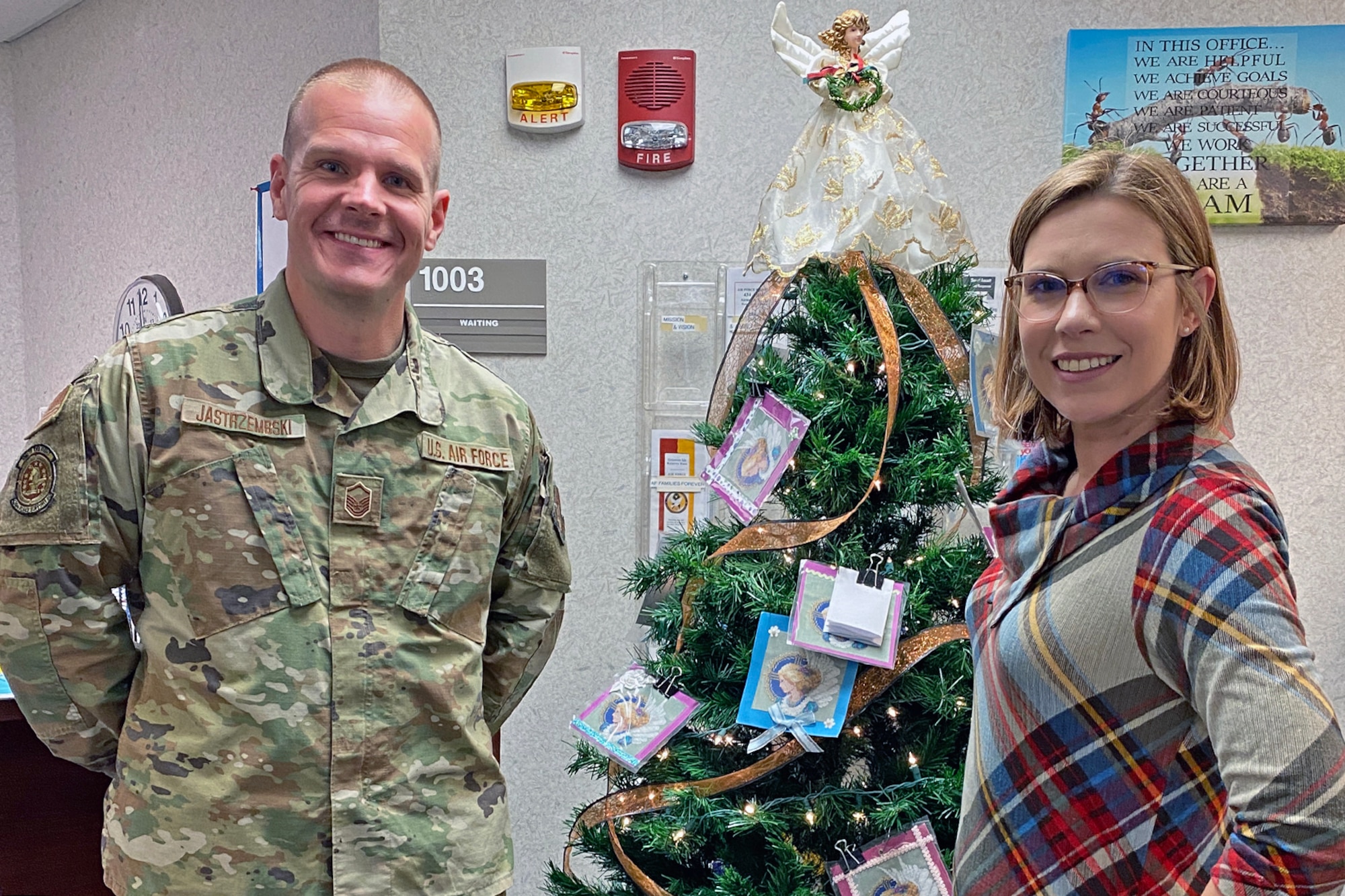 Master Sgt. Jason Jastrzembski, Airman and Family Readiness flight chief, and Stacey Pennington, Airman and Family Readiness program manager pose in front of a Christmas tree at Grissom Air Reserve Base, Ind. on November 6, 2021. The tree, decorated with angels, is symbolic of the "Angel Tree" program that Airmen and Family Readiness runs, which benefits Grissom Airmen and civilians around the holidays with anonymous gift donations. (U.S. Air Force photo by Master. Sgt. Rachel Barton)
