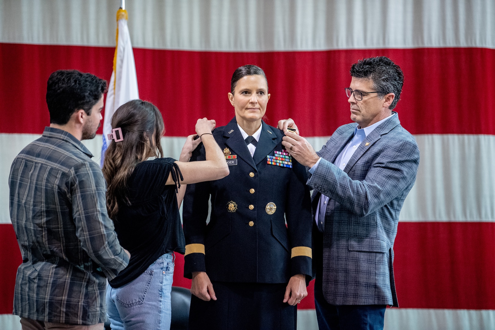 Col. Michaelle M. Munger is promoted to the rank of brigadier general by her husband and children at Joint Forces Headquarters, Charleston, West Virginia, Dec. 2, 2021. Munger became the first female general officer in the history of the West Virginia Army National Guard and will serve as Special Assistant to the Adjutant General for the West Virginia National Guard. (U.S. Army National Guard photo by Edwin L. Wriston)