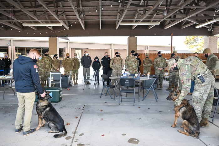 Military working dog Jimo (left) with former handler Staff Sgt. Patrick Cushing, 75th Security Forces Squadron, and MWD Bastas with former handler Staff Sgt. Tyler Hopkins, 75th SFS, are recognized during their retirement celebration Dec. 10, 2021, at Hill Air Force Base, Utah. MWDs Jimo and Bastas retired honorably after serving six years each with the 75th SFS at Hill. (U.S. Air Force photo by Cynthia Griggs)