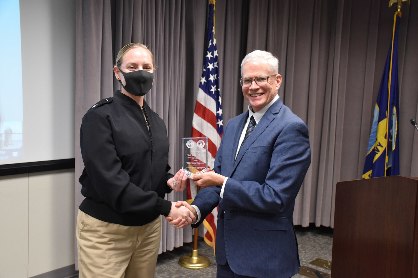 Dr. William Burnett, Technical Director, Naval Meteorology and Oceanography Command (CNMOC), presents Commander Kathryn Coyle with a graduation award at the FY2020 CNMOC Executive Leadership Program graduation ceremony at Stennis Space Center, MS, Nov. 19, 2021. CNMOC directs and oversees more than 2,500 globally-distributed military and civilian personnel who collect, process and exploit environmental information to assist Fleet and Joint Commanders in all warfare areas to make better decisions faster than the adversary.