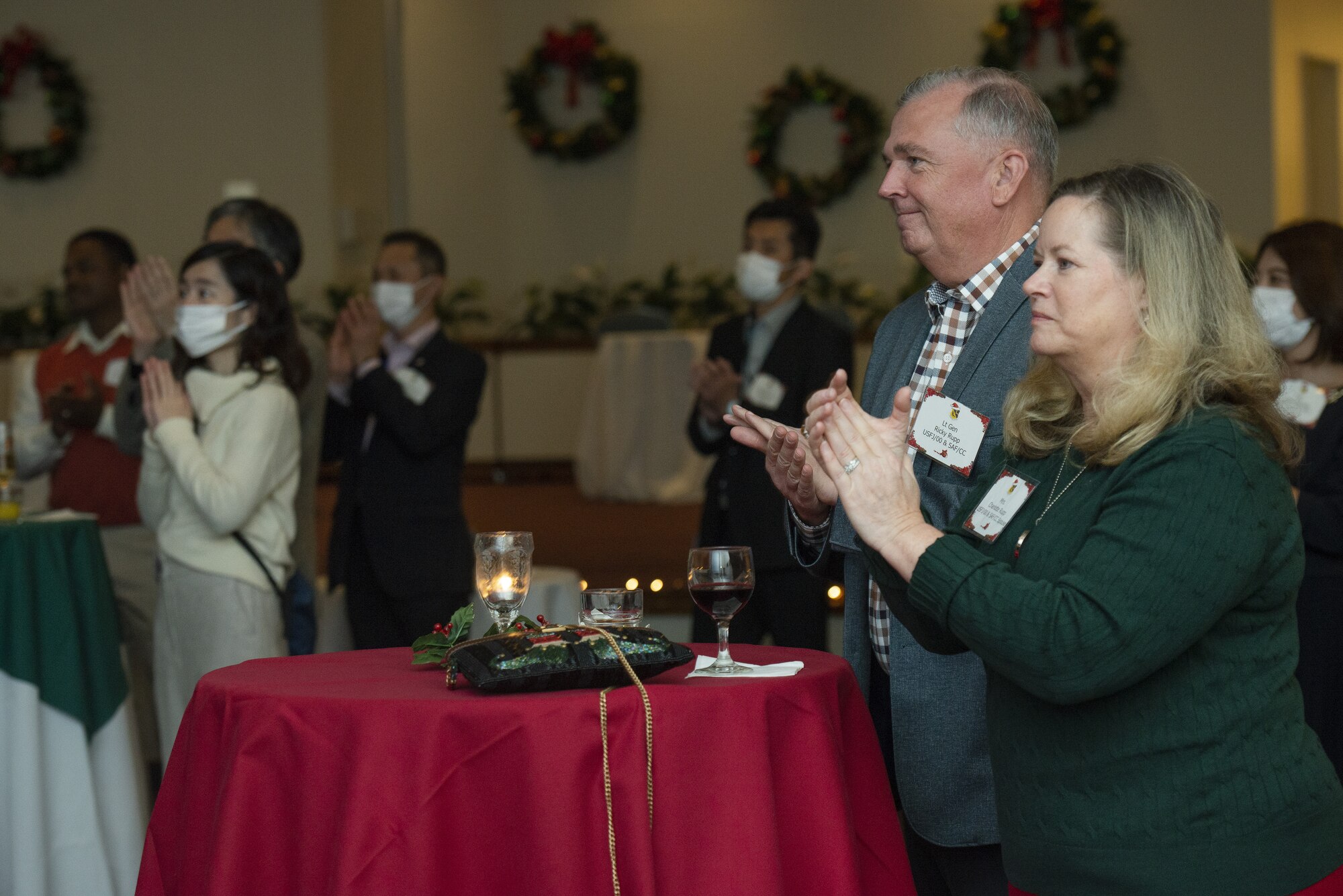 Lt. Gen. Ricky Rupp, U.S. Forces Japan and 5th Air Force commander, and his wife Charlotte Rupp, give a round of applause at the end of a Yokota High School musical performance during the 374th AW Holiday Social at the Yokota Officers Club at Yokota Air Base, Japan, Dec. 11, 2021. The event was an opportunity for wing leadership and Japanese partners from the JASDF, Japan America Air Force Goodwill Association, friendship clubs, and Government of Japan, to celebrate the holiday season together. Attendees were able to strengthen their relationships while enjoying live music performed by the Yokota High School and a children’s ballet dance. (U.S. Air Force photo by Tech. Sgt. Christopher Hubenthal)
