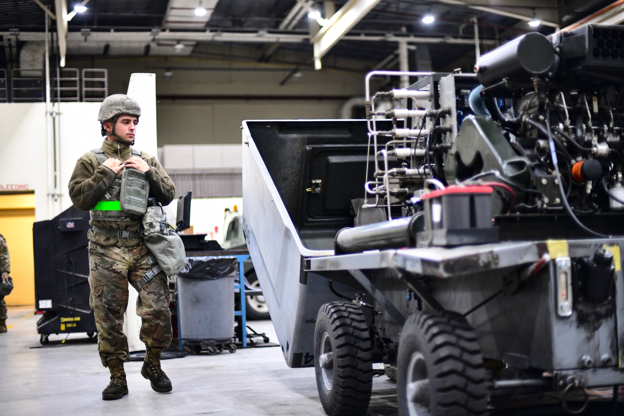 An Airman walks past a vehicle.