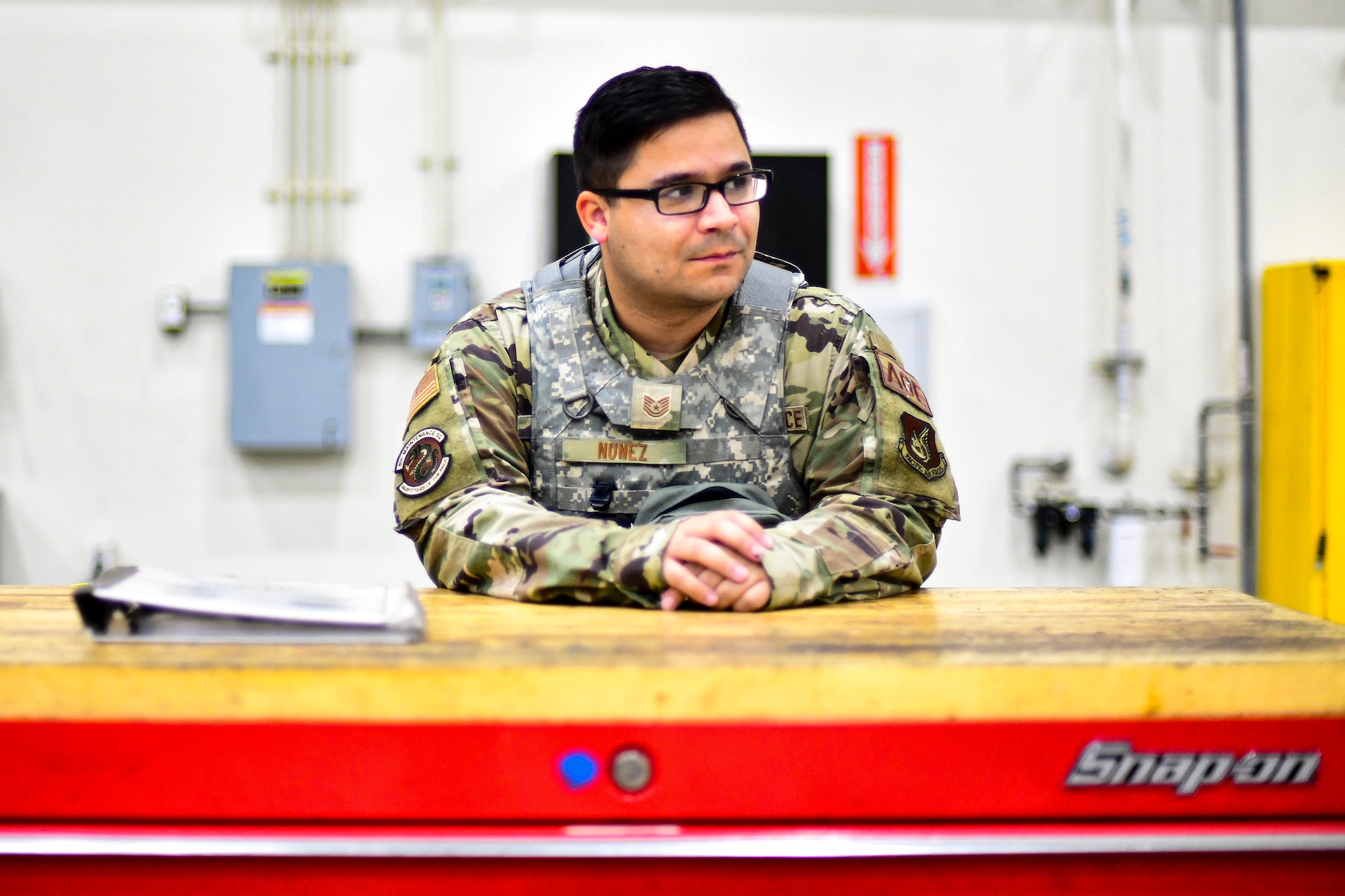 An Airman stands behind a tool box.