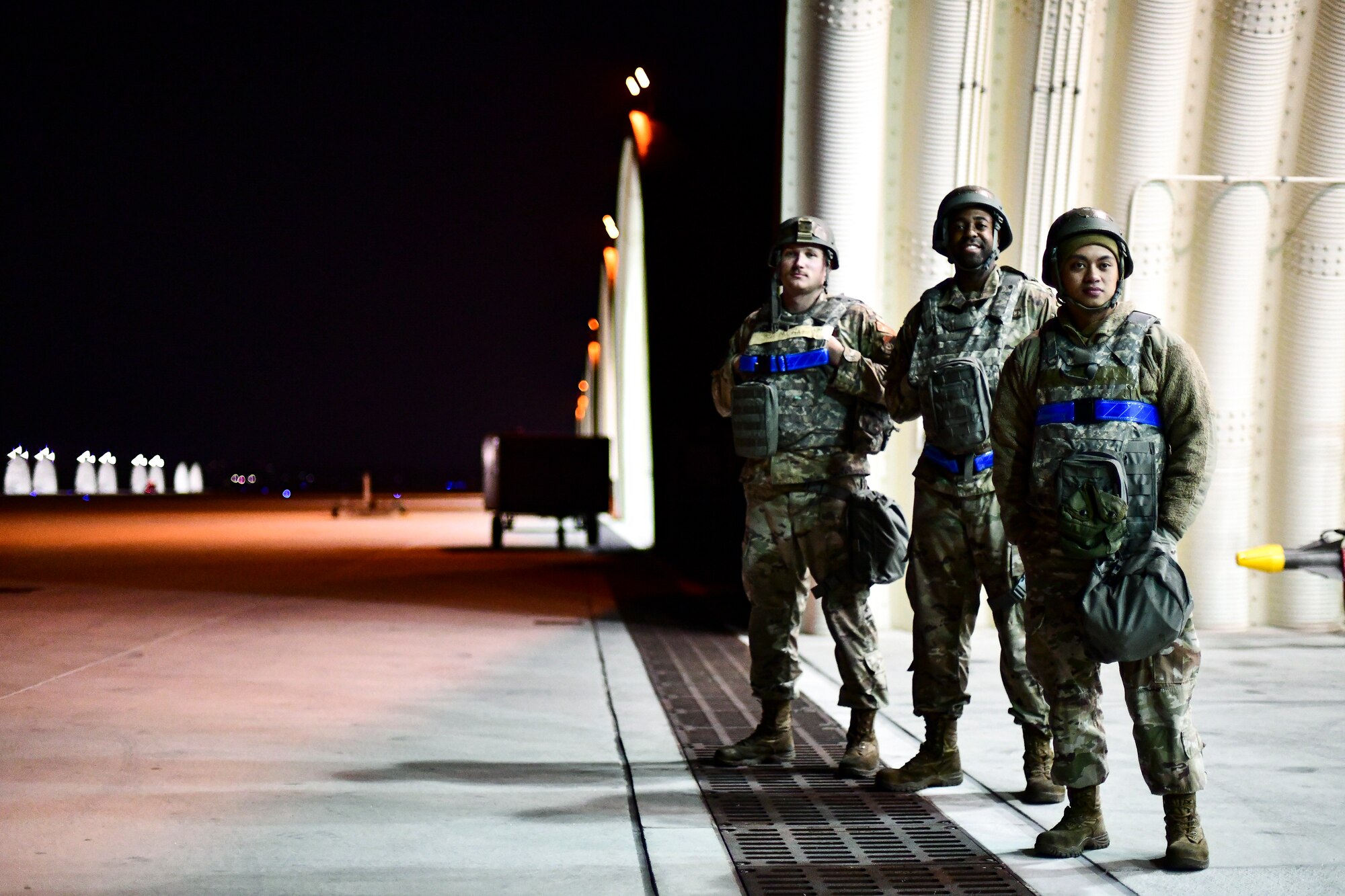 Airmen stand together under a hangar.