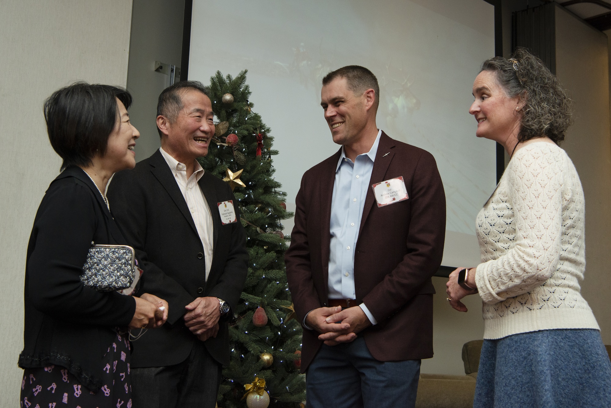 Col. Andrew Campbell, center right, 374th Airlift Wing commander, and his wife Katie Campbell, right, talk to Yoshiyuki Sugiyama, Japan America Air Forces Goodwill Association (JAAGA) president and former Japan Air Self Defense Force Air Defense Command commander, and his wife Fumiko Sugiyama, during the 374th AW Holiday Social at the Yokota Officers Club at Yokota Air Base, Japan, Dec. 11, 2021. The social brought members of Yokota Air Base, Japan Air Self Defense Force and Japanese civic leaders together, to celebrate the holiday and talk about their friendship moving forward. Lt. Gen. Ricky Rupp, U.S. Forces Japan and 5th Air Force commander, and Christine Bordine, Defense Special Representative-Japan director, also attended the event to interact with local civic leaders. (U.S. Air Force photo by Tech. Sgt. Christopher Hubenthal)