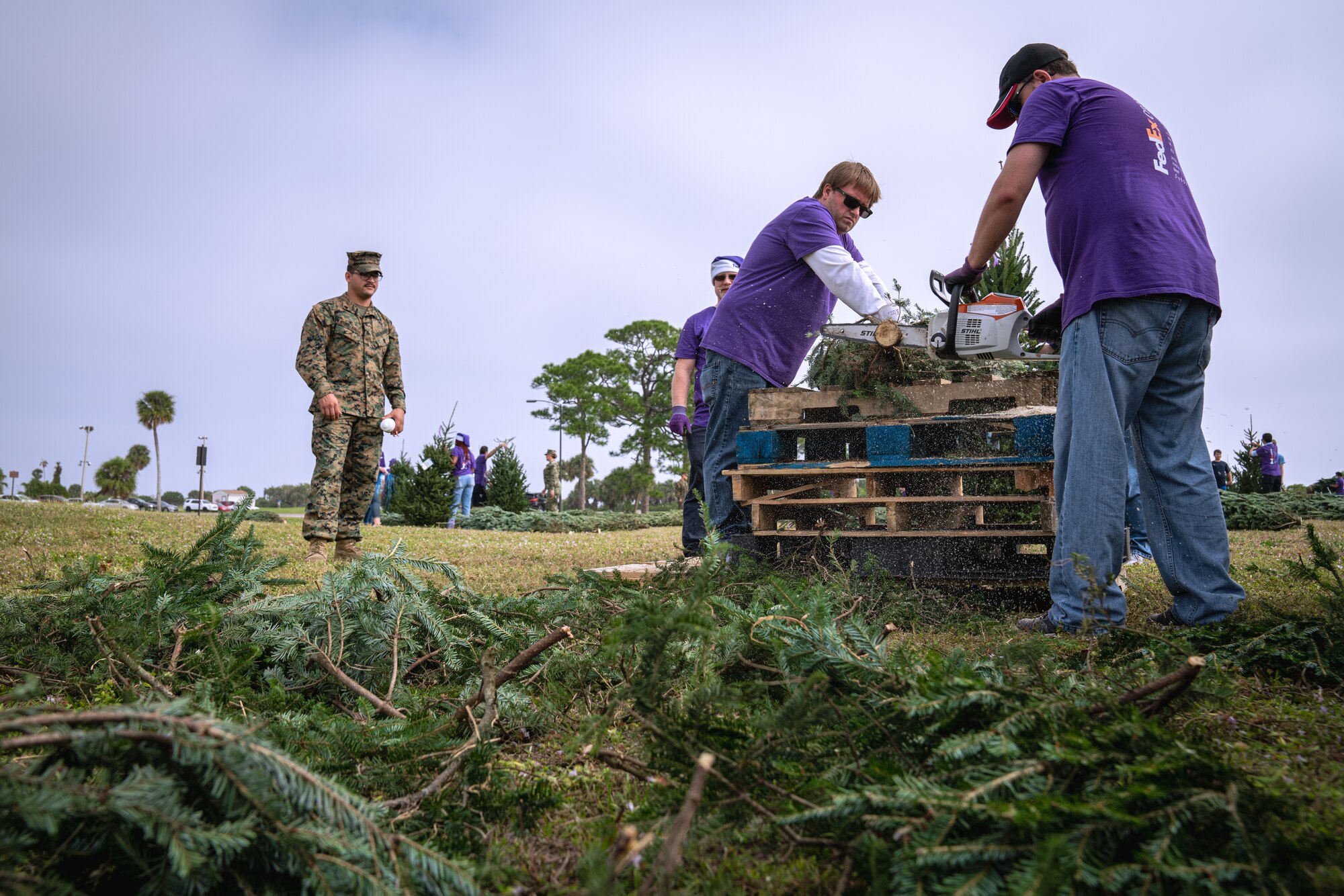 Volunteers trim Christmas trees during the Trees for Troops event at MacDill Air Force Base, Florida, Dec. 9, 2021.