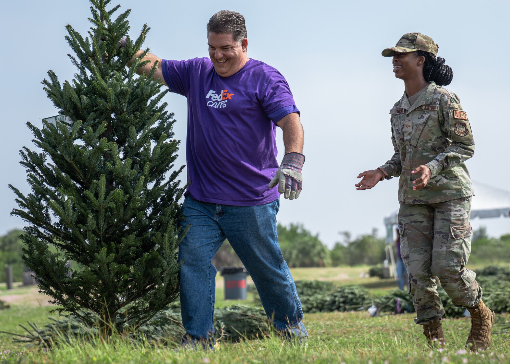 U.S. Air Force Senior Airman Briah Byrd, 6th Aerospace Medicine Squadron aerospace medical service technician, picks up a Christmas tree during the Trees for Troops event at MacDill Air Force Base, Florida, Dec. 9, 2021.