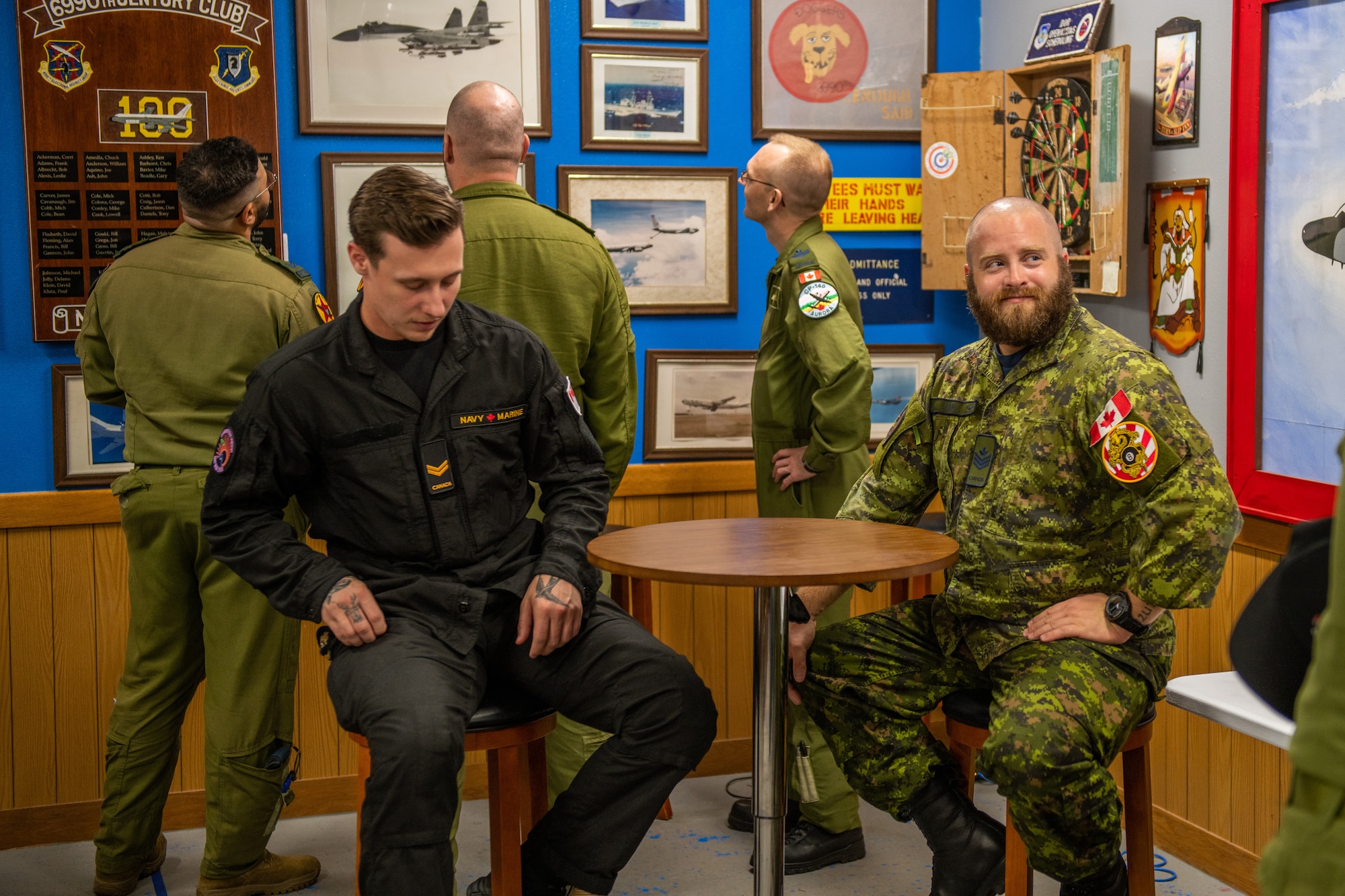 Canadian military members sit in the heritage room of a U.S. Air Force squadron