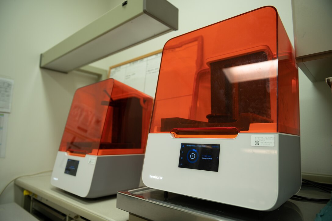 3D printers sit on a counter.