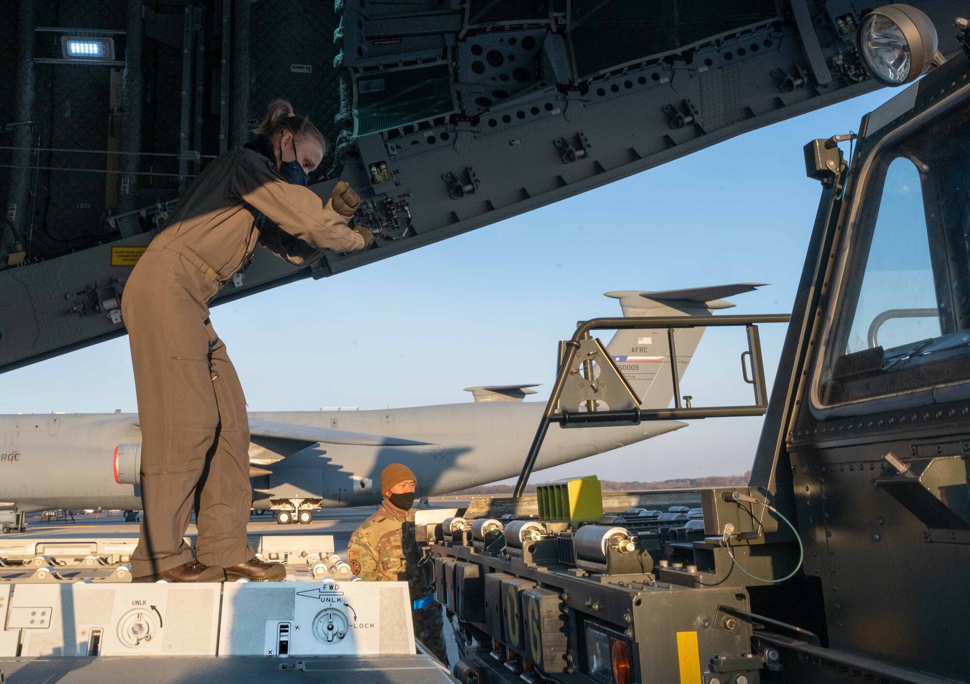 A Belgian air force member marshals a K-loader to the ramp of a Belgian air force A400M Atlas during a foreign military sales mission at Dover Air Force Base, Delaware, Dec. 9, 2021. Missions such as this strengthen the alliance between the U.S. and Belgium. The U.S. and Belgium work bilaterally and in international and regional organizations to encourage economic and political cooperation and assistance to developing countries. (U.S. Air Force photo by Senior Airman Faith Schaefer)