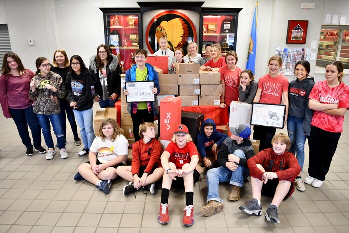 Students pose with robotics kits.