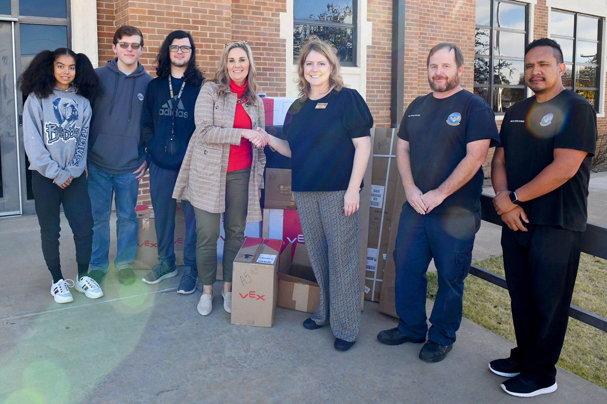 Kathy Keller-Darby (center) principal of Altus High School (AHS) poses alongside three AHS STEM students (left) and three members of the Altus Air Force Base (AAFB) STEM council (right) at AHS