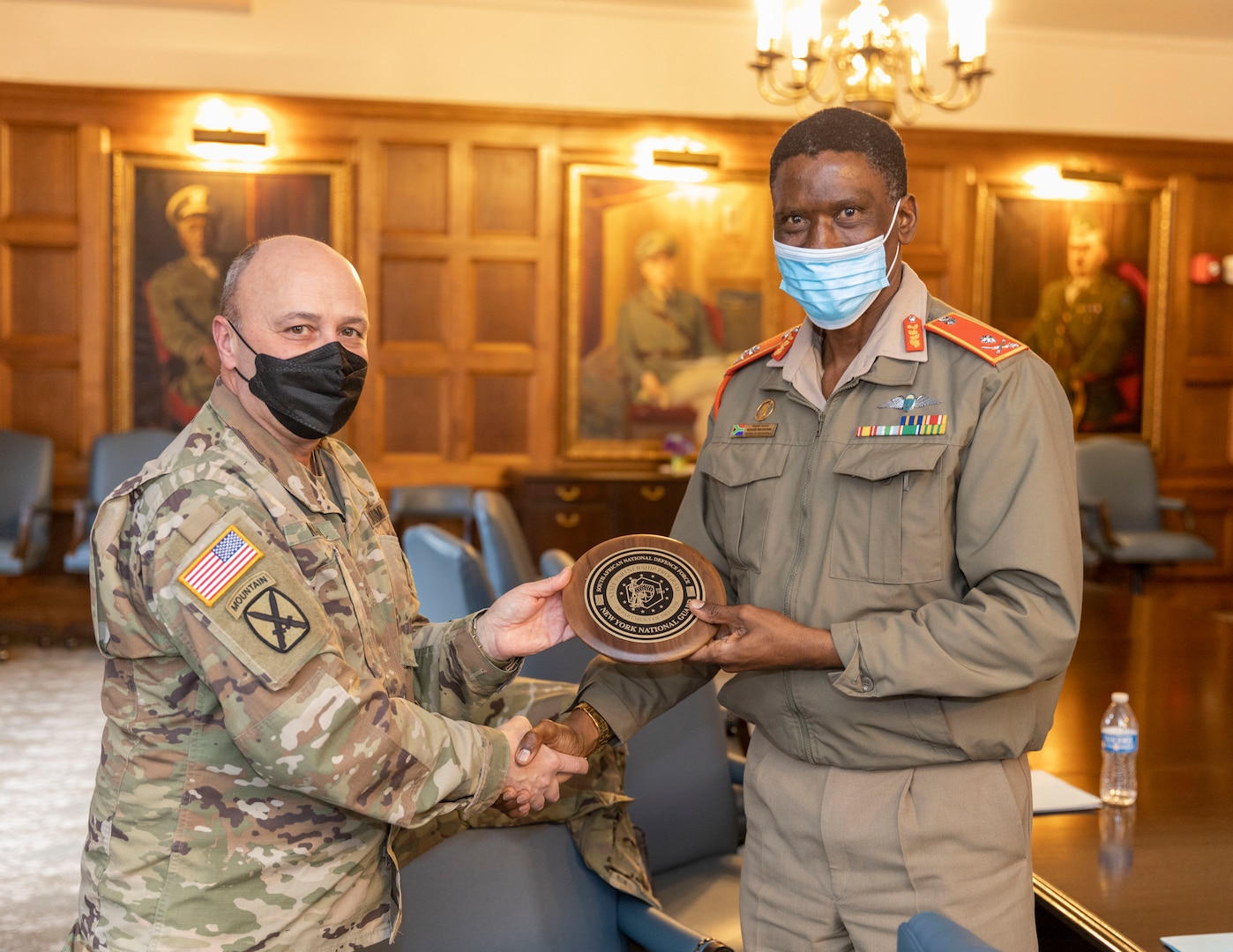 New York National Guard Maj. Gen. Michel Natali, the assistant adjutant general, presents a plaque to Brig. Gen. Richard Maponyane, the South Africa defense attaché, in New York Dec. 9, 2021, during a meeting to discuss State Partnership Program initiatives. The New York Army National Guard and South Africa have been partners in the program since 2003.