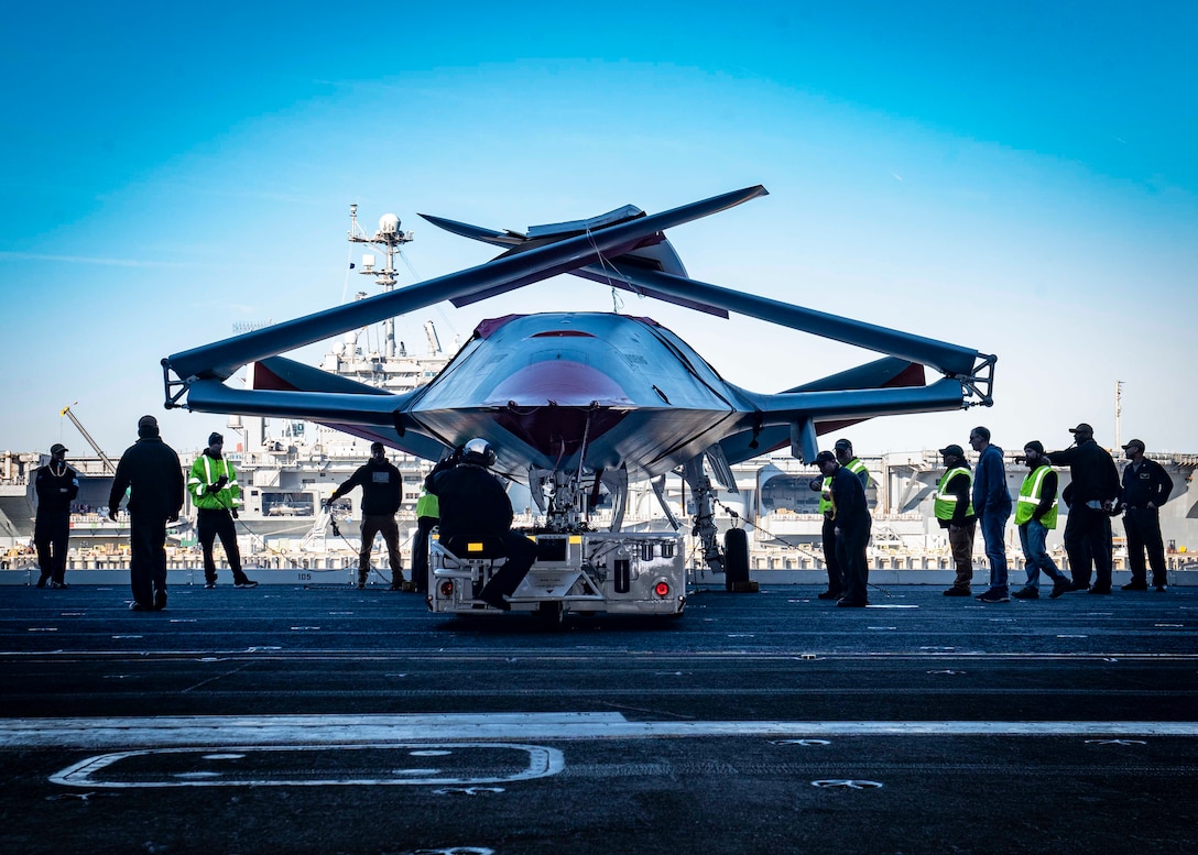 Sailors and Boeing team members prepare to move a Boeing unmanned MQ-25 aircraft into the hangar bay aboard the aircraft carrier USS George H.W. Bush (CVN 77). The MQ-25 will be the worlds first operational, carrier-based unmanned aircraft and is integral to the future carrier air wing (CVW). It will provide an aerial refueling capability that extends the range, operational capability and lethality of the CVW and carrier strike group (CSG). GHWB provides the national command authority flexible, tailorable war fighting capability through the carrier strike group that maintains maritime stability and security in order to ensure access, deter aggression and defend U.S., allied and partner interests.  (U.S. Navy photo by Mass Communication Specialist 3rd Class Noah J. Eidson)