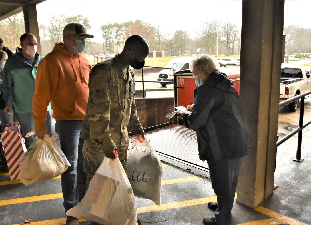 Master Sgt. Don Wilson is first in line to have gifts provided by Arnold Air Force Base personnel during the 2021 Angel Tree drive checked off by Carlene White with the Center for Family Development before they are loaded for transport on Dec. 6, 2021, to the center in Shelbyville, where the presents will be wrapped and prepared for distribution. The workforce at Arnold provided Christmas gifts for more than 200 area children during the latest Angel Tree campaign. (U.S. Air Force photo by Bradley Hicks)(This image was altered by obscuring badges for security purposes.)