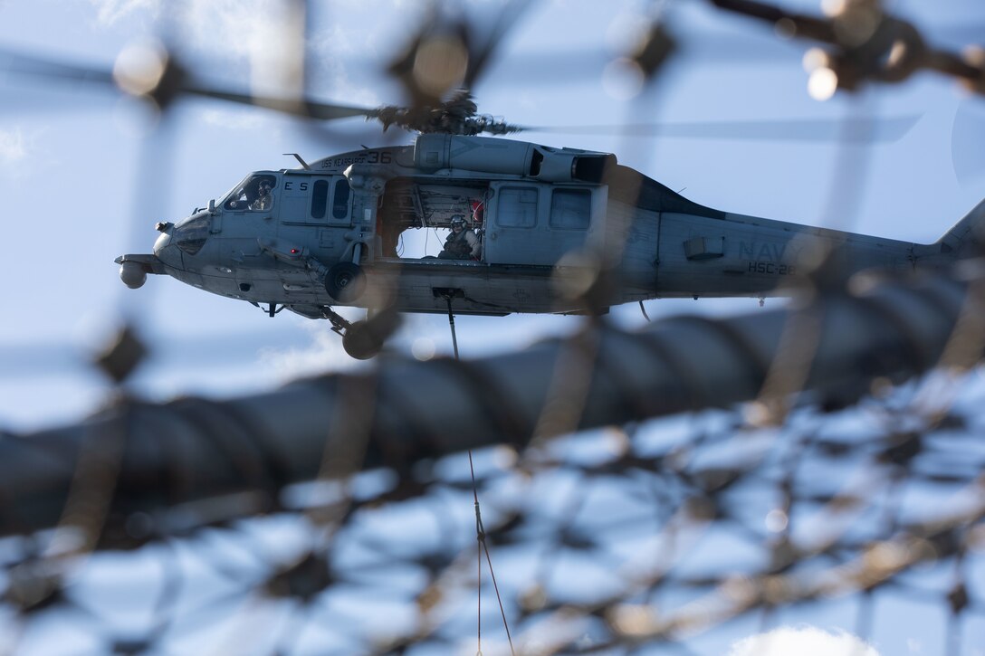 U.S. Navy pilots with Helicopter Sea Combat Squadron 28, transport supplies from USNS Leroy Grumman (T-AO-195), using MH-60S Seahawk Helicopters during a replenishment at sea (RAS), aboard amphibious assault ship USS Kearsarge (LHD 3), Dec. 11, 2021. RAS is conducted to transfer necessities such as munitions, supplies, and food from one ship to another while underway. (U.S. Marine Corps photo by Cpl. Yvonna Guyette)