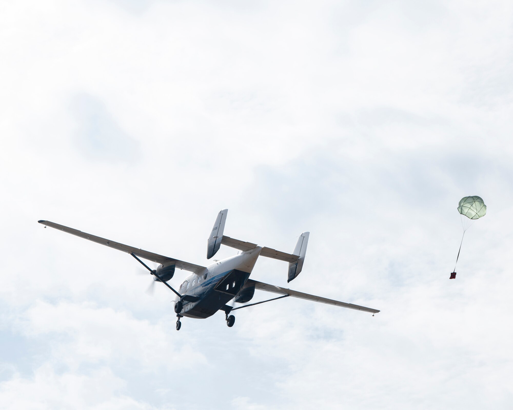 A C-145 Combat Coyote aircraft drops a test sand bag.