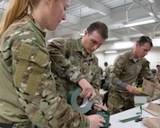 Airman building improvised parachute bundles