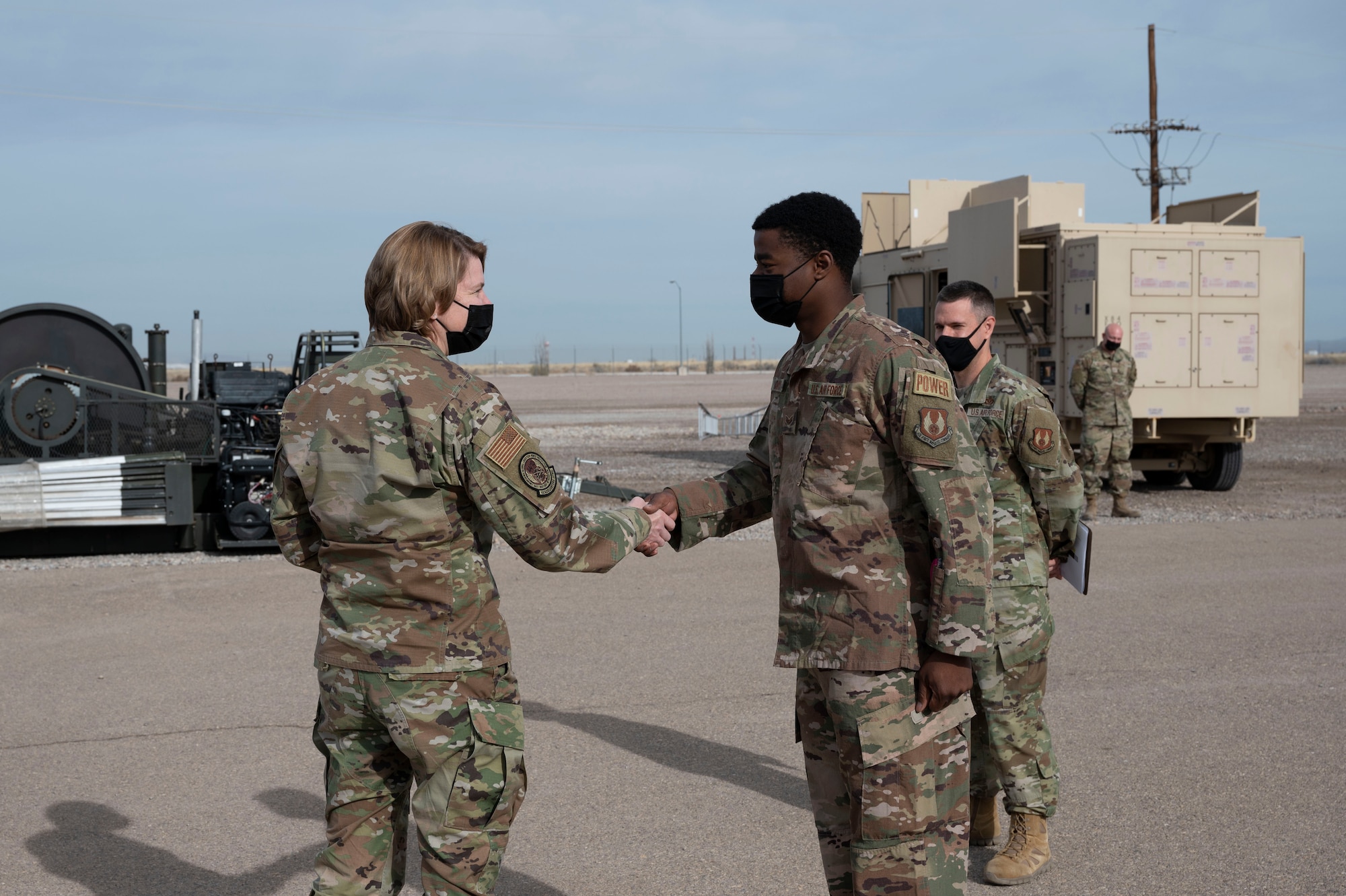 Maj. Gen. Constance McCauley von Hoffman, U.S. Air Force Materiel Command logistics director, coins Senior Airman Jordan Davis, 635th Materiel Maintenance Group electrical power production journeyman, during a familiarization tour at the Basic Expeditionary Airfield Resources (BEAR) base, Dec. 09, 2021, on Holloman Air Force Base, N.M. During her immersion at BEAR base, von Hoffman learned about the different operations and projects that occur daily on the installation. (U.S. Air Force photo by Airman 1st Class Antonio Salfran)