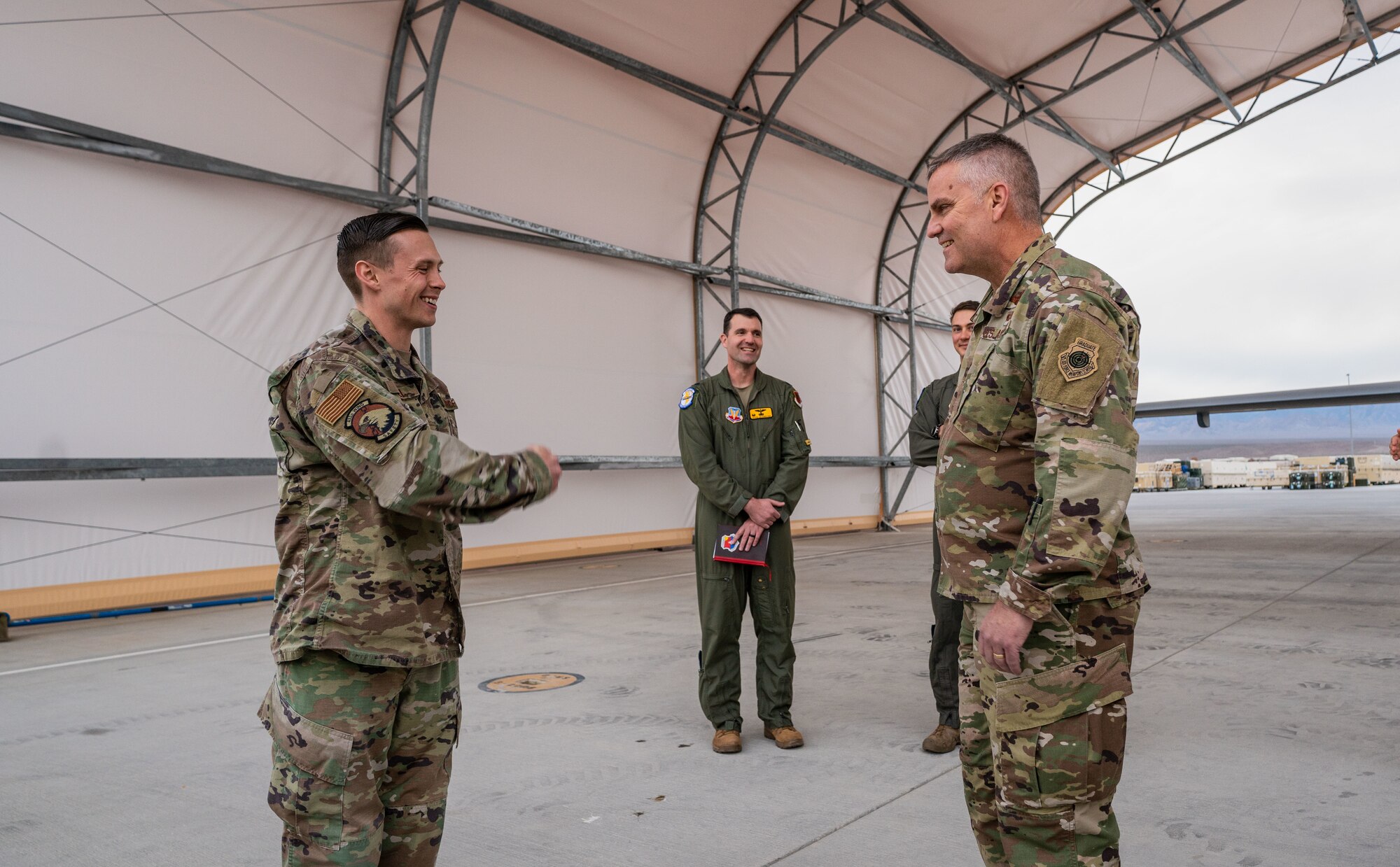 Tech Sgt. Devin bell thanks Maj. Gen. Michael G Koscheski for coining him while under a sunshade on the flightline.