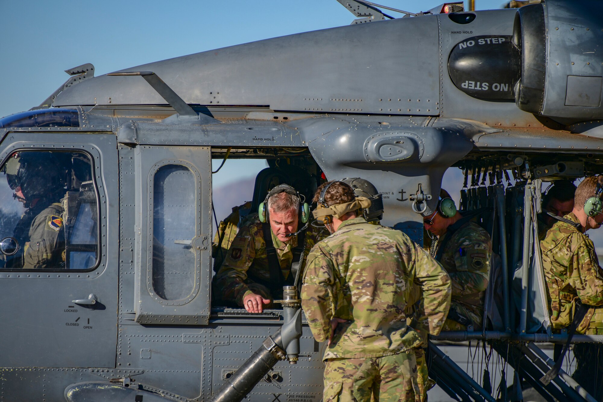A photo of airmen in and around a helicopter.