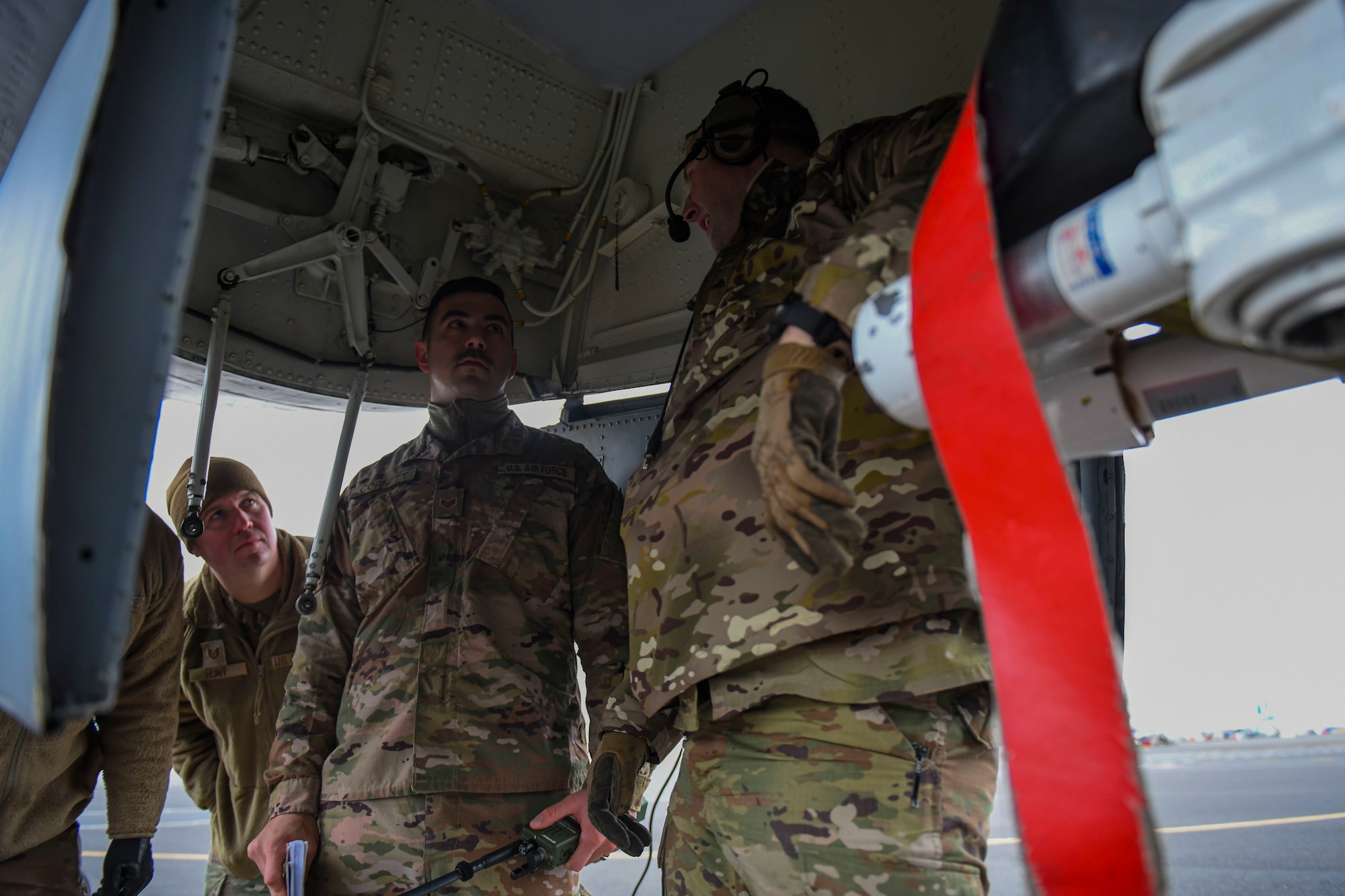 U.S. Air Force Tech. Sgt. Patrick Forbes, 92nd Maintenance Squadron flying crew chief (right), teaches Staff Sgt. Bradley Cornett, 92nd Operation Support Squadron air traffic controller (middle), and Tech. Sgt. Brian Hunt, 92nd Security Forces Squadron flight chief (left), how to provide maintenance to a KC-135 Stratotanker as part of multi-capable Airmen concept training at the Grant County International Airport in Moses Lake, Washington, Dec. 7, 2021. MCA was originally developed under Gen. Charles Q. Brown Jr.’s, U.S. Air Force chief of staff, action orders “Accelerate Change or Lose,” something Fairchild is now implementing and practicing on a grand scale to strengthen and lengthen Airmen capabilities. (U.S. Air Force photo by Senior Airman Kiaundra Miller)