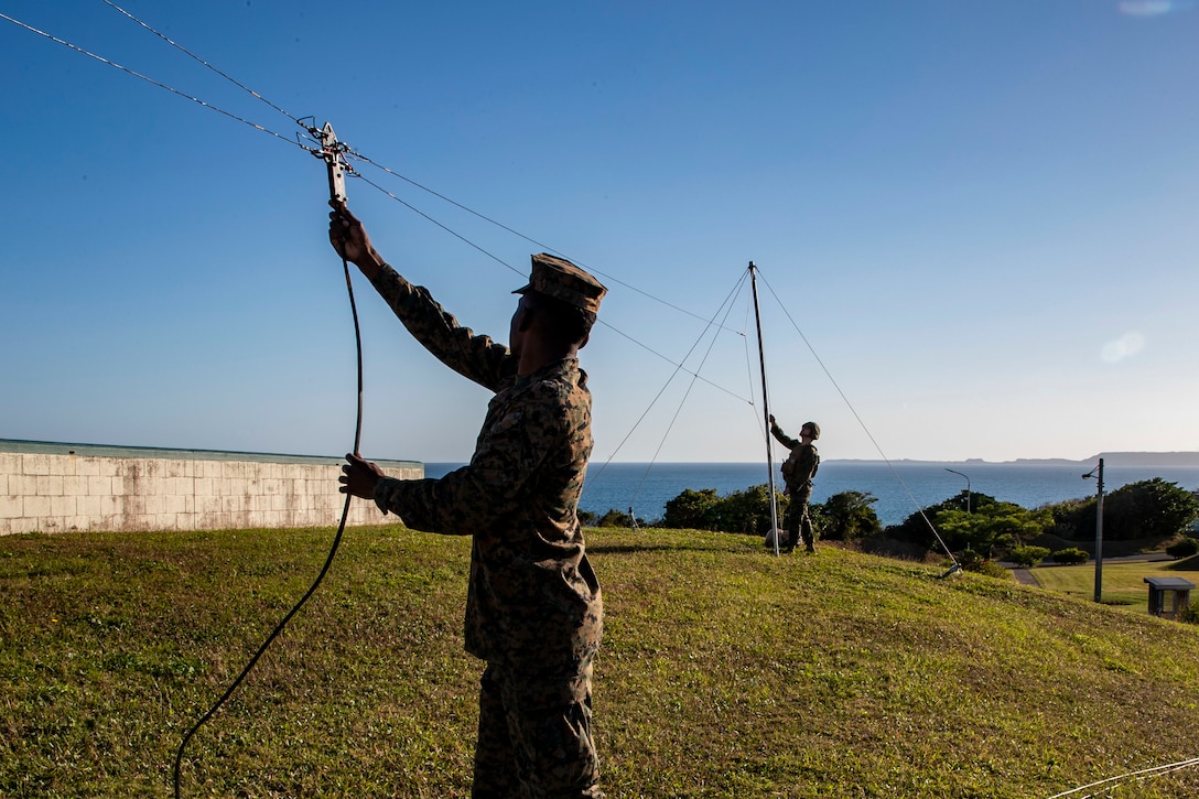 U.S. Marine Cpl. Brendan Terrible (foreground), a radio operator, and Lance Cpl. Levii Khalfaoui McLeod, (background),  a data systems administrator with 7th Communication Battalion, III Marine Expeditionary Force Information Group, adjust a horizontal dipole field expedient antenna while reinforcing 3D Marine Expeditionary Brigade during exercise Yama Sakura 81 on Camp Courtney, Okinawa, Japan Dec. 10, 2021. Yama Sakura 81 is the largest joint and bilateral command post exercise (CPX) co-sponsored by U.S. Army Pacific (USARPAC) and the JGSDF designed to increase joint force lethality, enhance design and posture, and strengthen alliances and partnerships (U.S. Marine Corps photo by Staff Sergeant Andrew Ochoa).