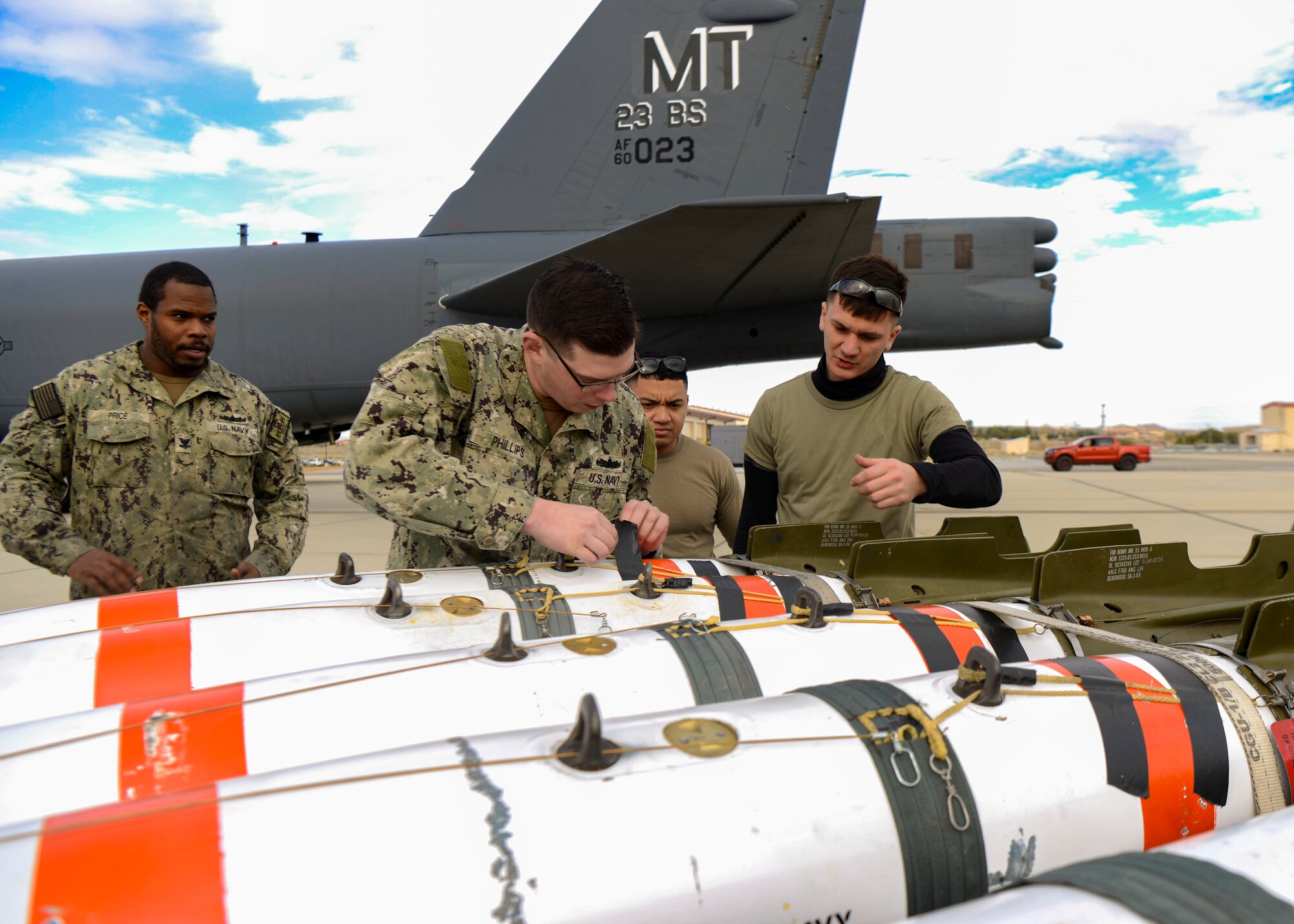 Airmen and sailors inspect mines