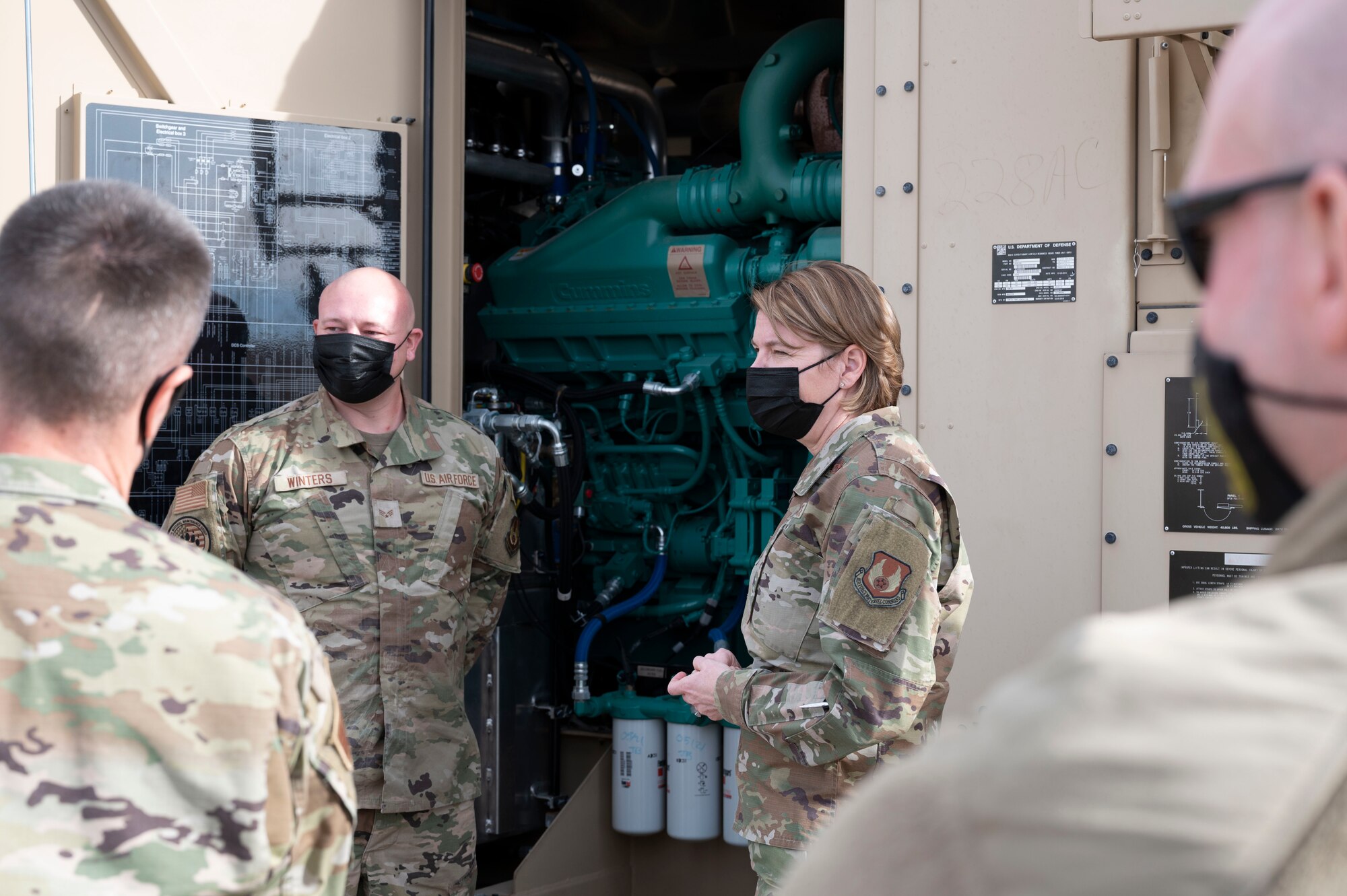 Maj. Gen. Constance McCauley von Hoffman, U.S. Air Force Materiel Command logistics director, and Senior Airman Jonathan Winters, 635th Materiel Maintenance Group electrical power production journeyman, take a deeper look at a Bear Power Unit (BPU) during a familiarization tour at the Basic Expeditionary Airfield Resources (BEAR) base, Dec. 09, 2021, on Holloman Air Force Base, N.M. The BPU generator is a portable power source that is used on Air Force expeditionary bases. (U.S. Air photo by Airman 1st Class Antonio Salfran)