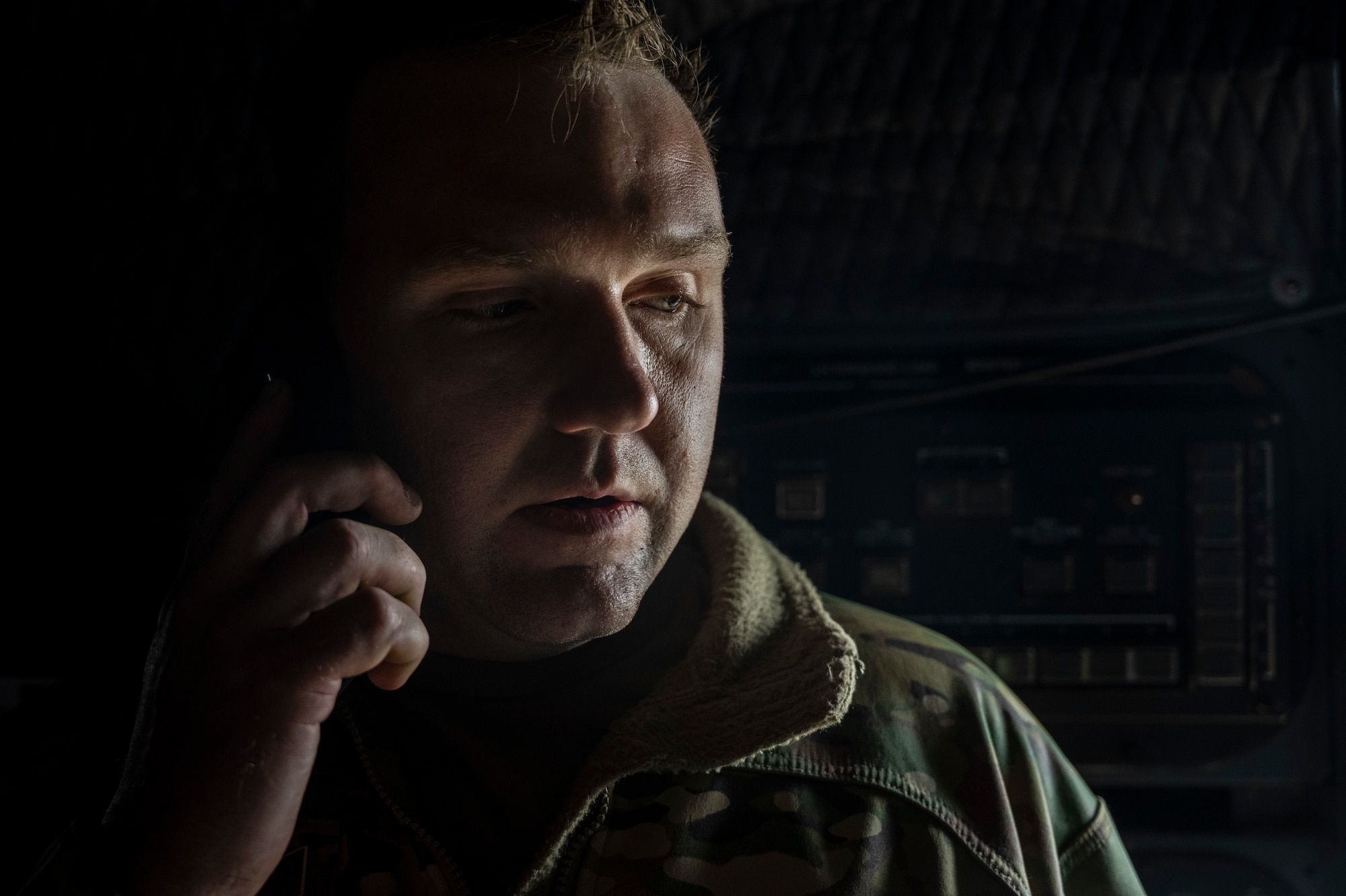 A portrait of a man in military uniform on the phone.