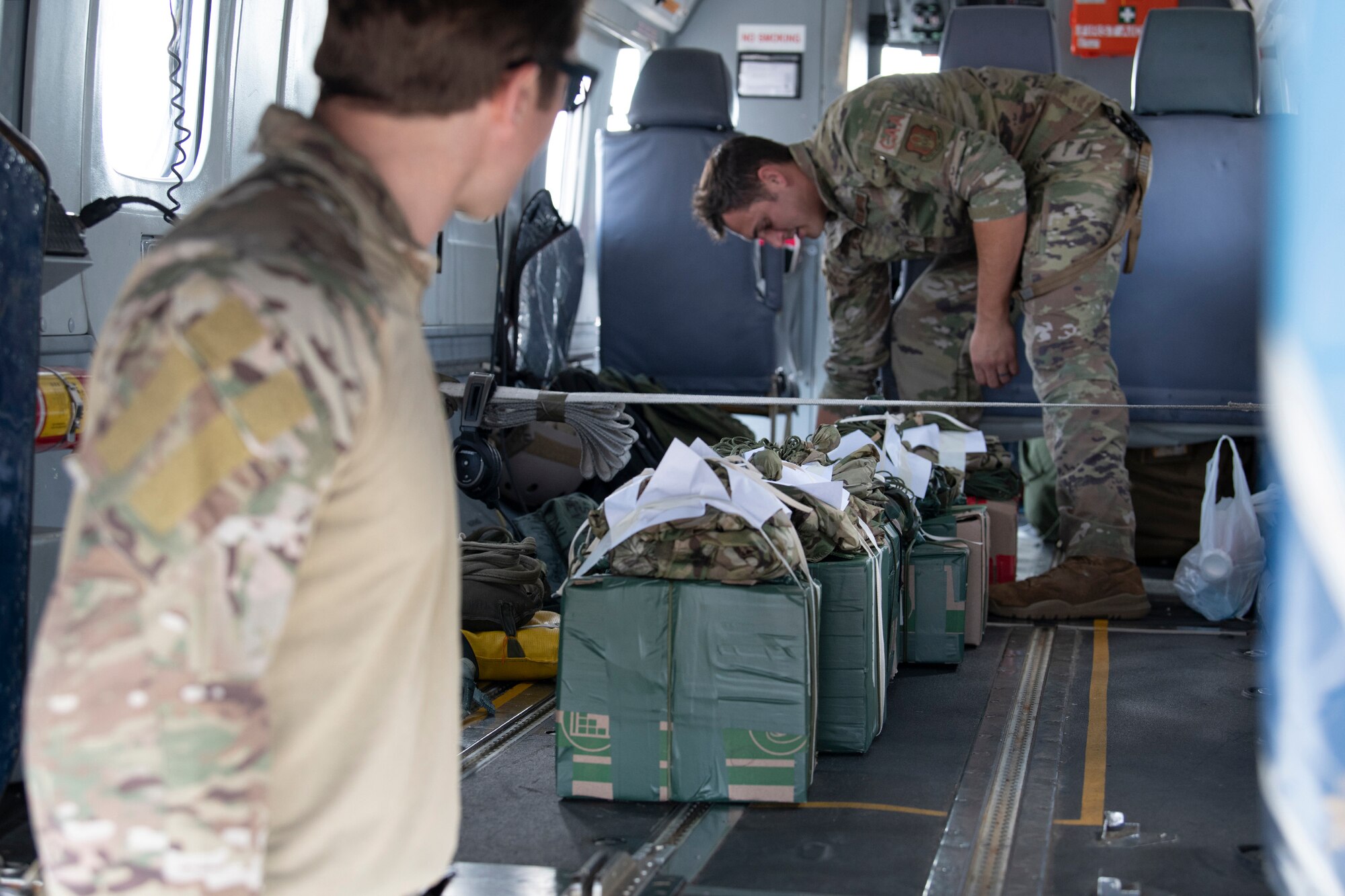 Loadmaster organizes improvised parachute bundles