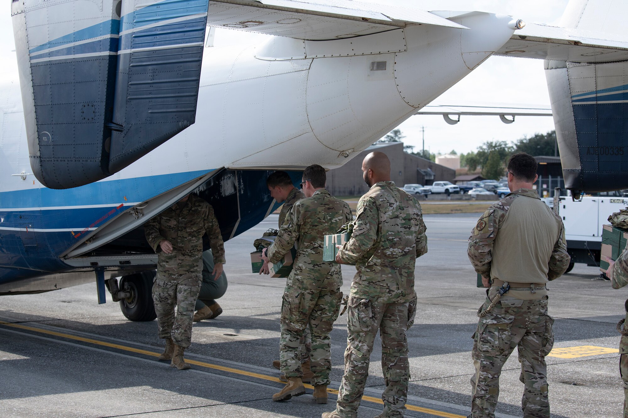 Airmen load a C-145A Combat Coyote aircraft with improvised parachute bundles.