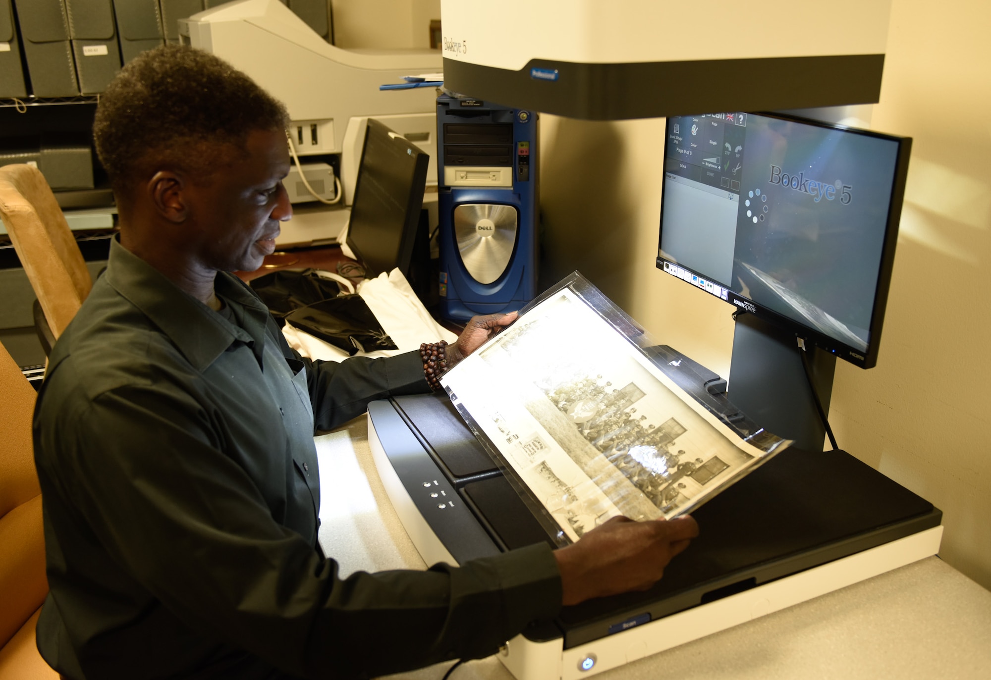 Tracy English scans a photo at Lackland History Office