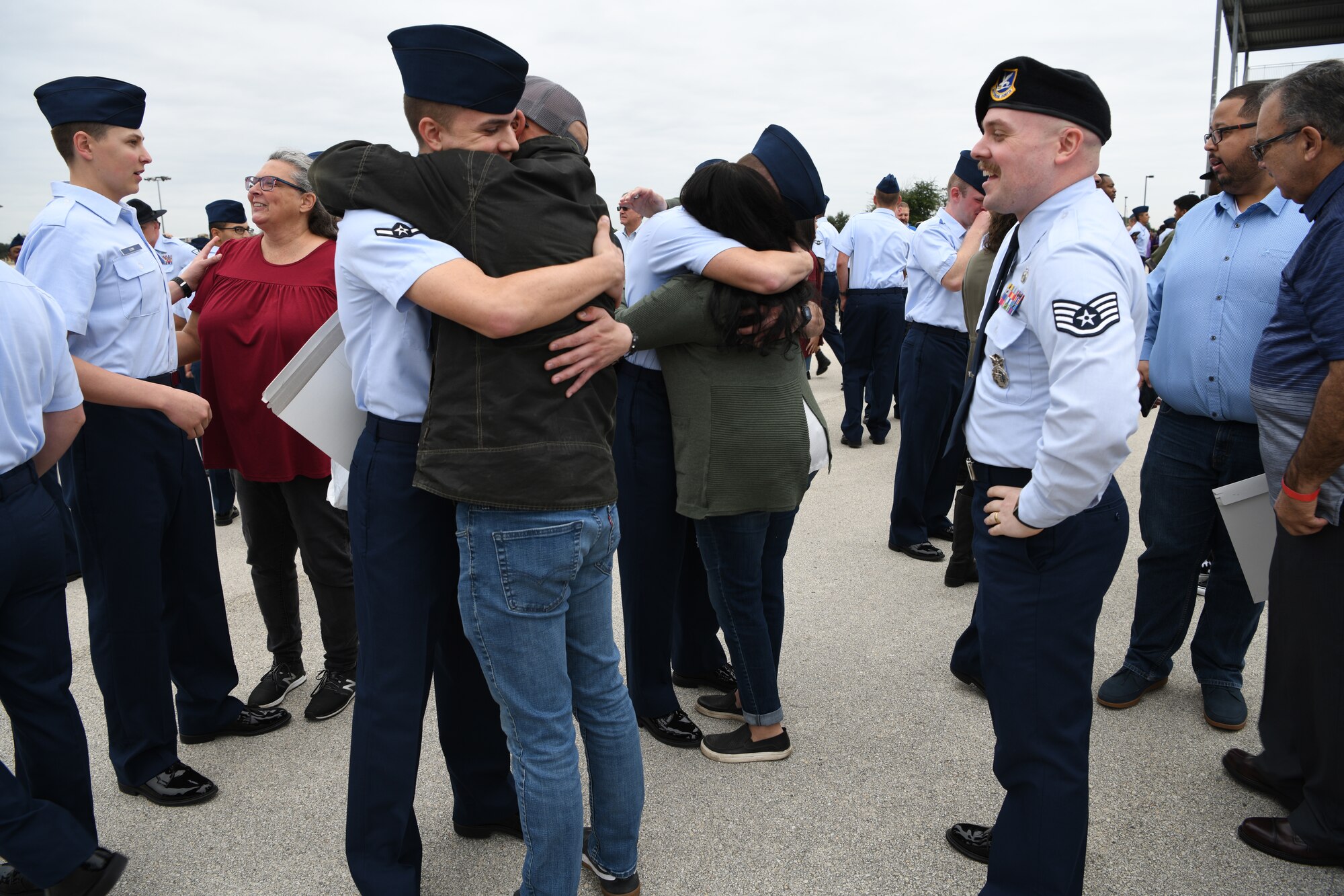 Then Staff Sgt. Zachary Smith, an enlisted accessions recruiter with the 313th Recruiting Squadron in New Hartford, New York, looks on while his younger brother, Airman Calvin Smith, embraces their father, Dan, a few minutes after a Basic Military Training graduation ceremony in Airman’s Arena at Joint Base San Antonio-Lackland, Texas, Nov. 24, 2021.