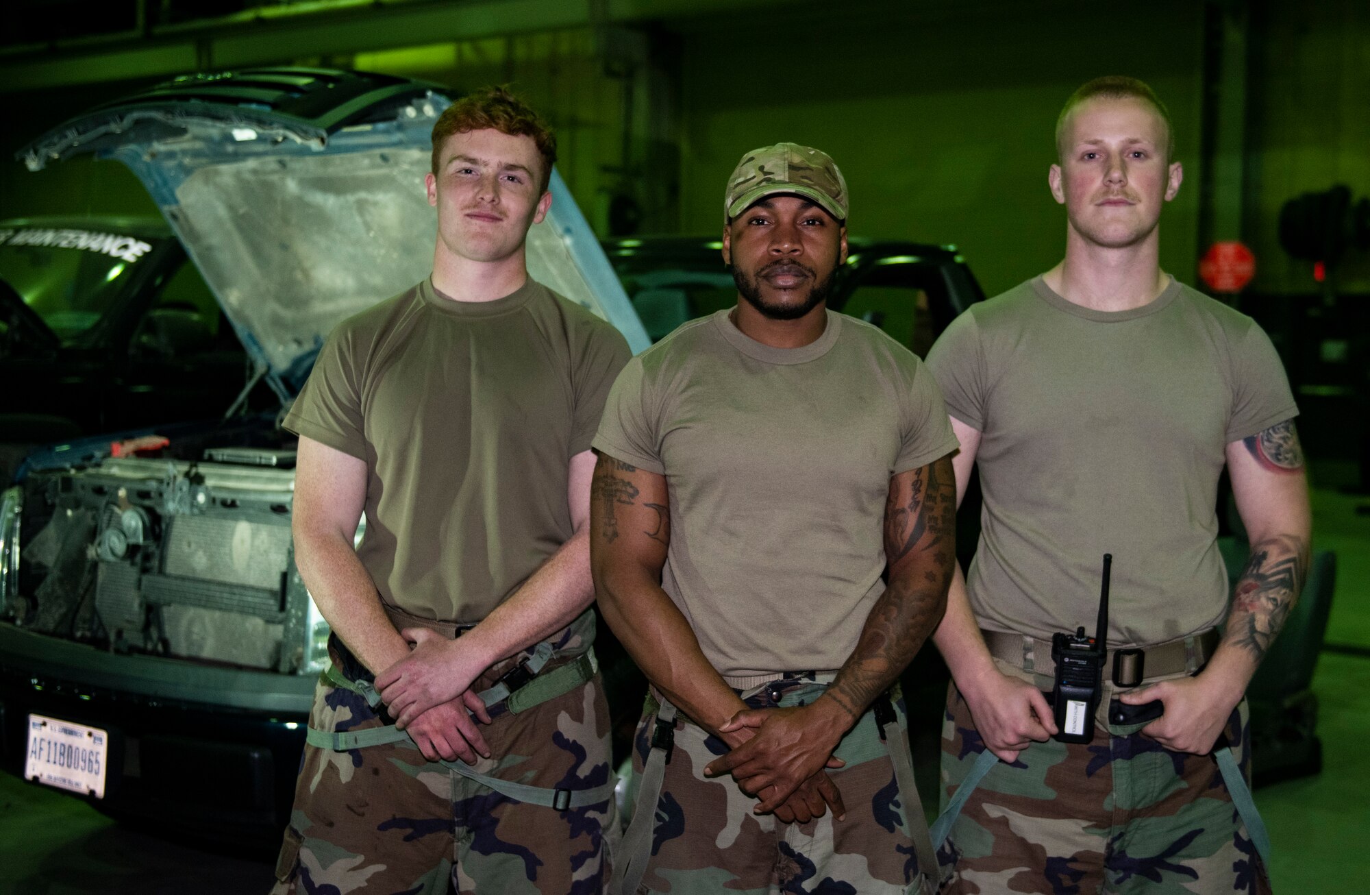 Senior Airman Thomas Matthews, 8th Logistics Readiness Squadron general purpose NCO in charge, Tech. Sgt. Roderick McKenzie, 8th LRS firetruck and refueling maintenance section chief, and Senior Airman Tyler Hower, 8th LRS vehicle management technician, stand in front of an active vehicle repair at Kunsan Air Base, Republic of Korea, Nov. 3, 2021. Vehicle management specialists inspect, troubleshoot and repair vehicles to ensure the Wolf Pack carries out the mission. (U.S. Air Force photo by Staff Sgt. Suzie Plotnikov)