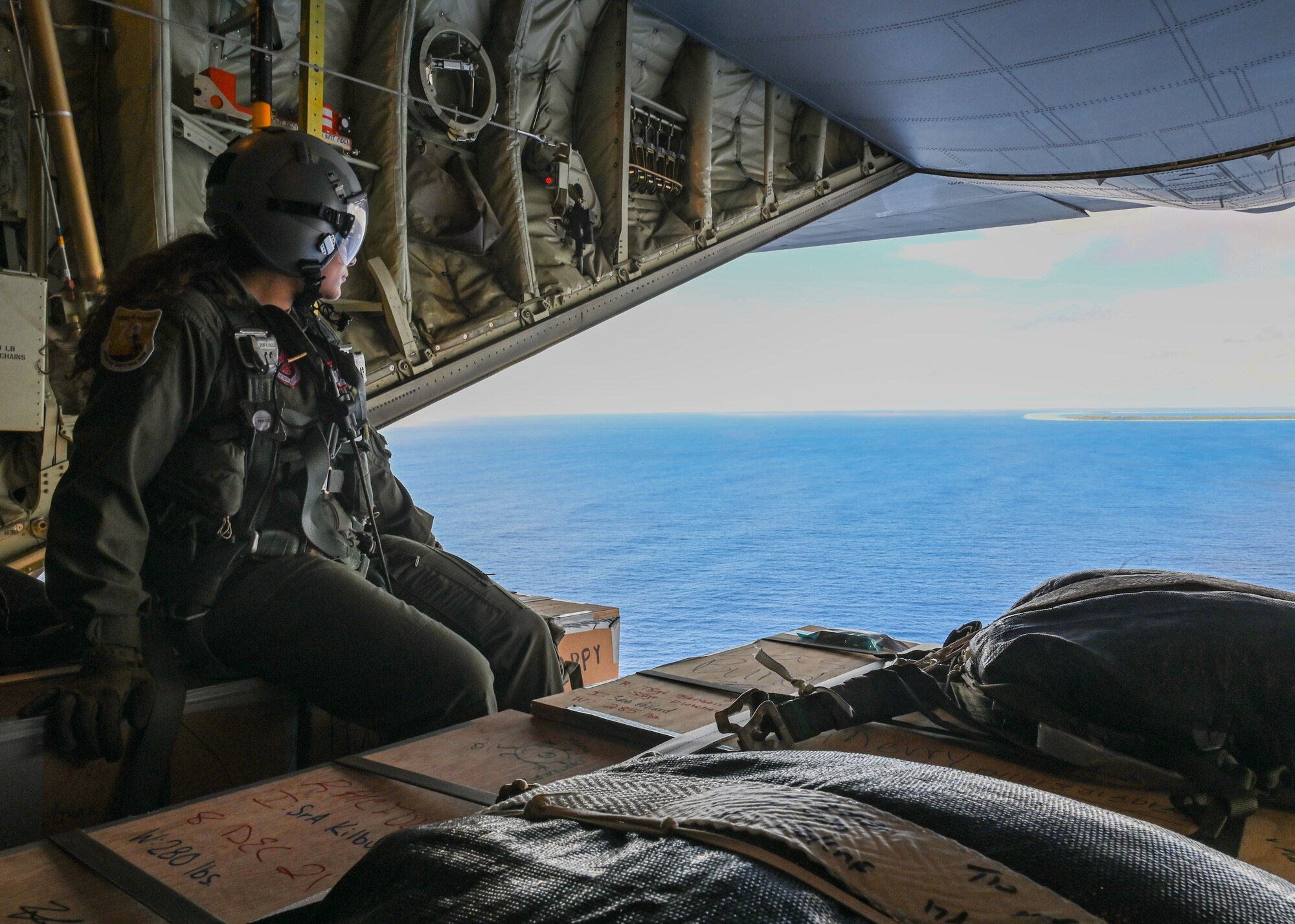 U.S. Air Force Senior Airman Kim Doyle, a loadmaster assigned to the 36th Airlift Squadron, Yokota Air Base, Japan, prepares to drop bundles off a U.S. Air Force C-130J during Operation Christmas Drop at Andersen Air Force Base, Guam, Dec. 10, 2021. Over the course of 10 days, crews will airdrop donated food, clothing, educational materials, and tools to 55 islanders throughout the South-Eastern Pacific, including the Federated States of Micronesia, and the Republic of Palau. (U.S. Air Force photo by Senior Airman Aubree Owens)